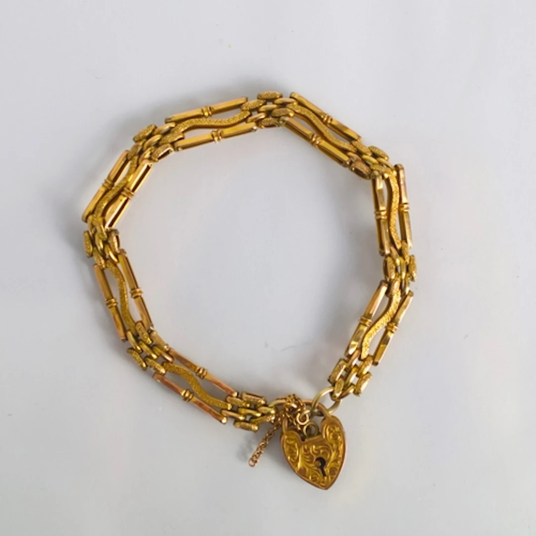 An early 20th century yellow metal bracelet, the gate link b...