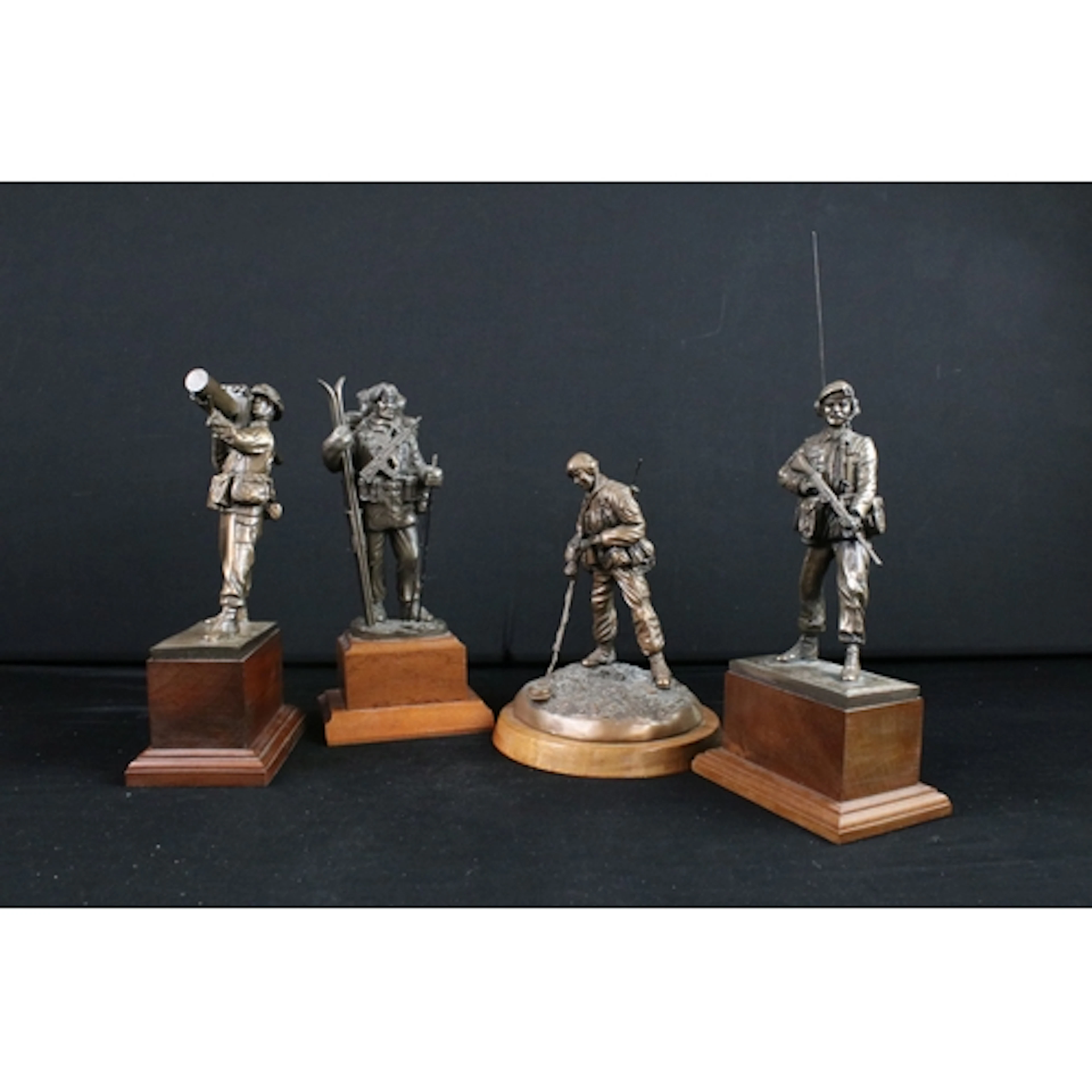 Four bronzed military figures, one modelled as a soldier sea...