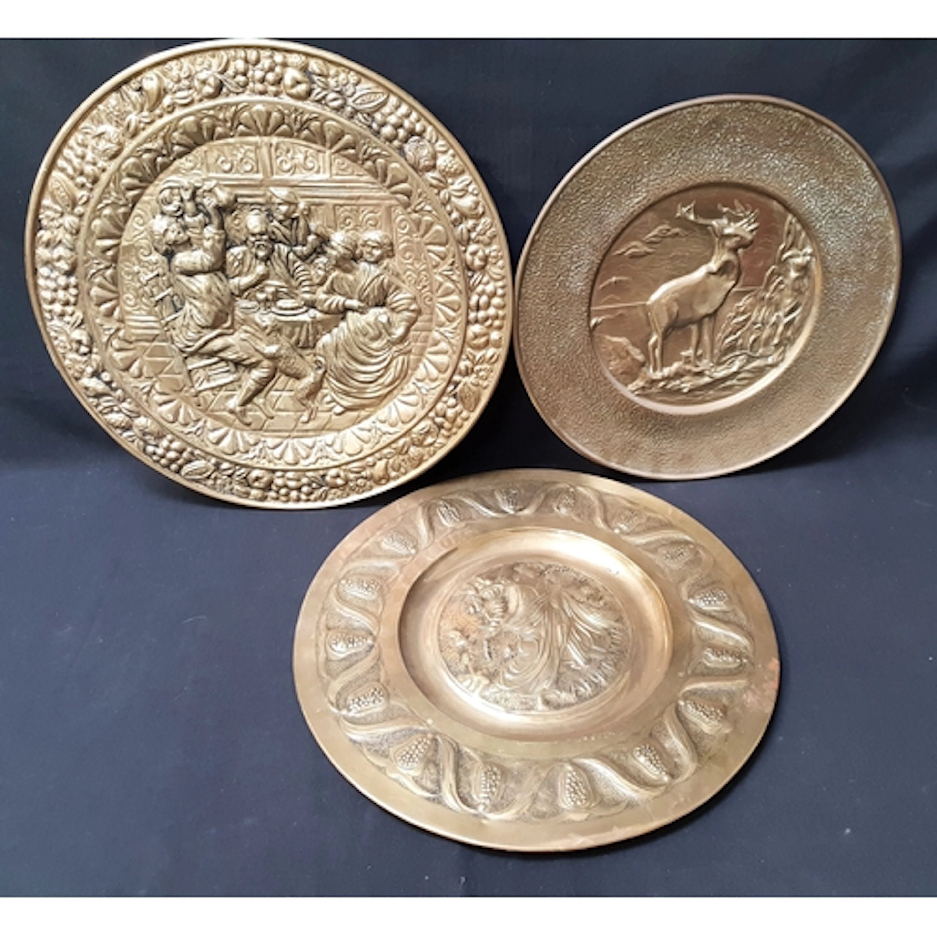 THREE RELIEF BRASS WALL CHARGERS one depicting Abundantia to...
