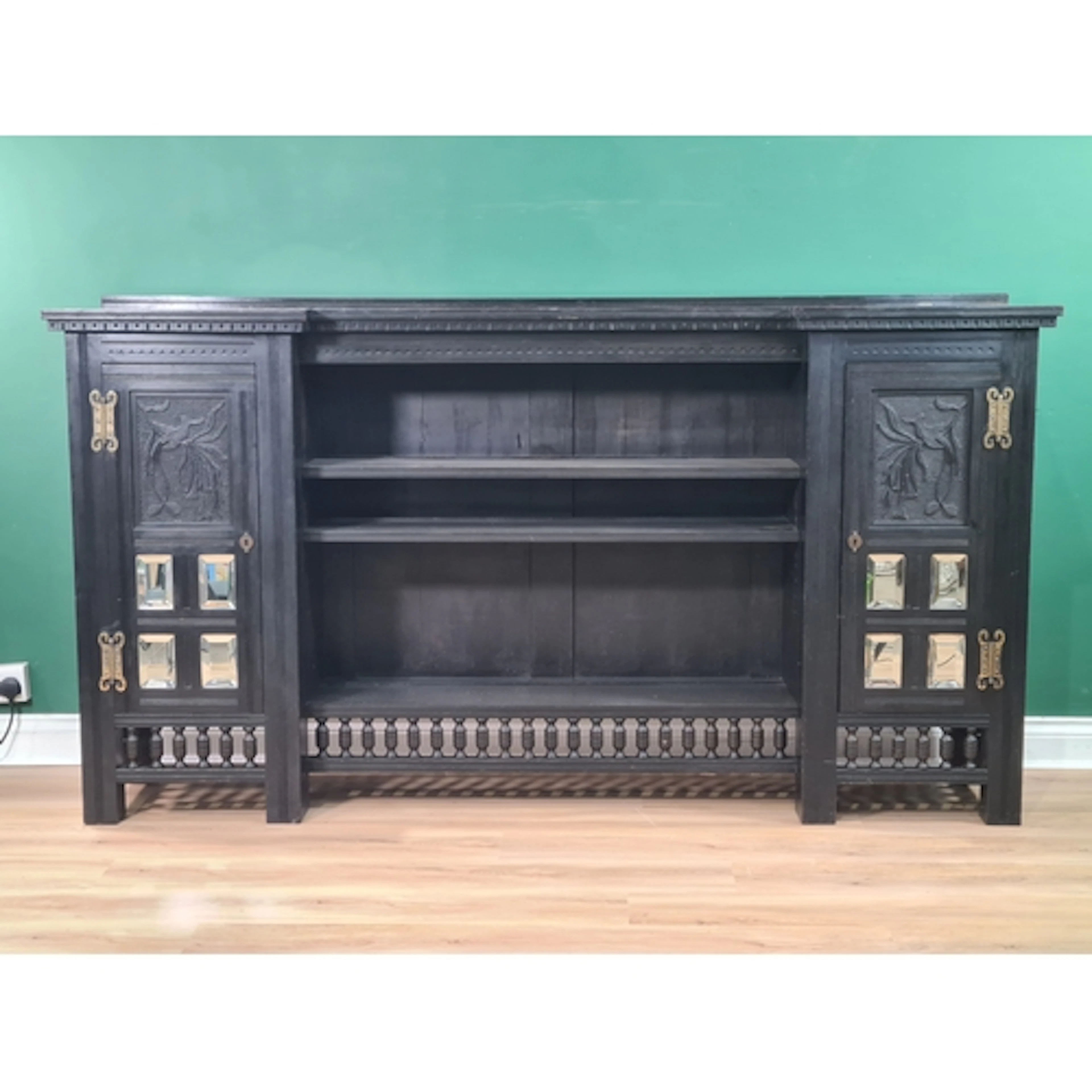 An Arts and Crafts ebonised Side Cabinet with inverted break...