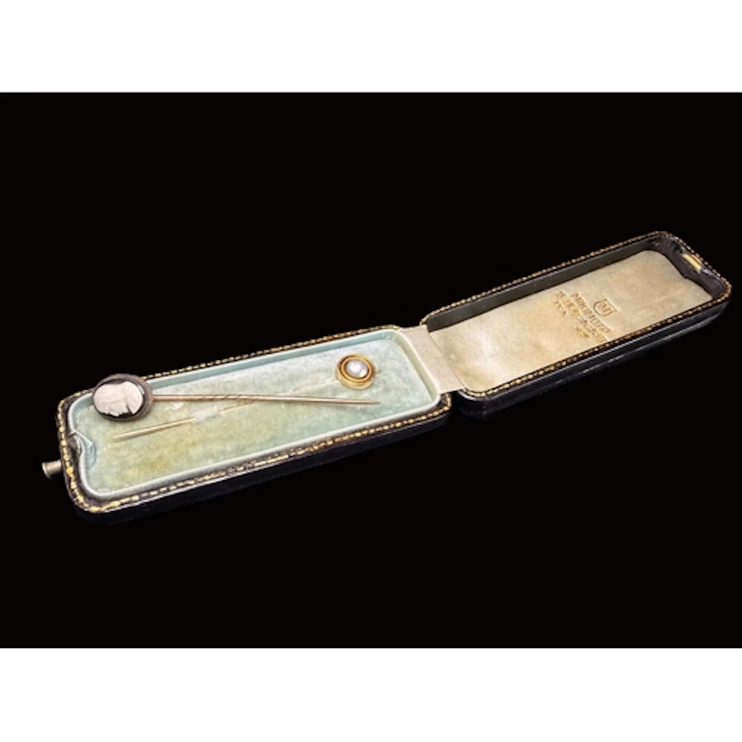 A Mikimoto pearl set yellow metal stick pin in Mikimoto leat...