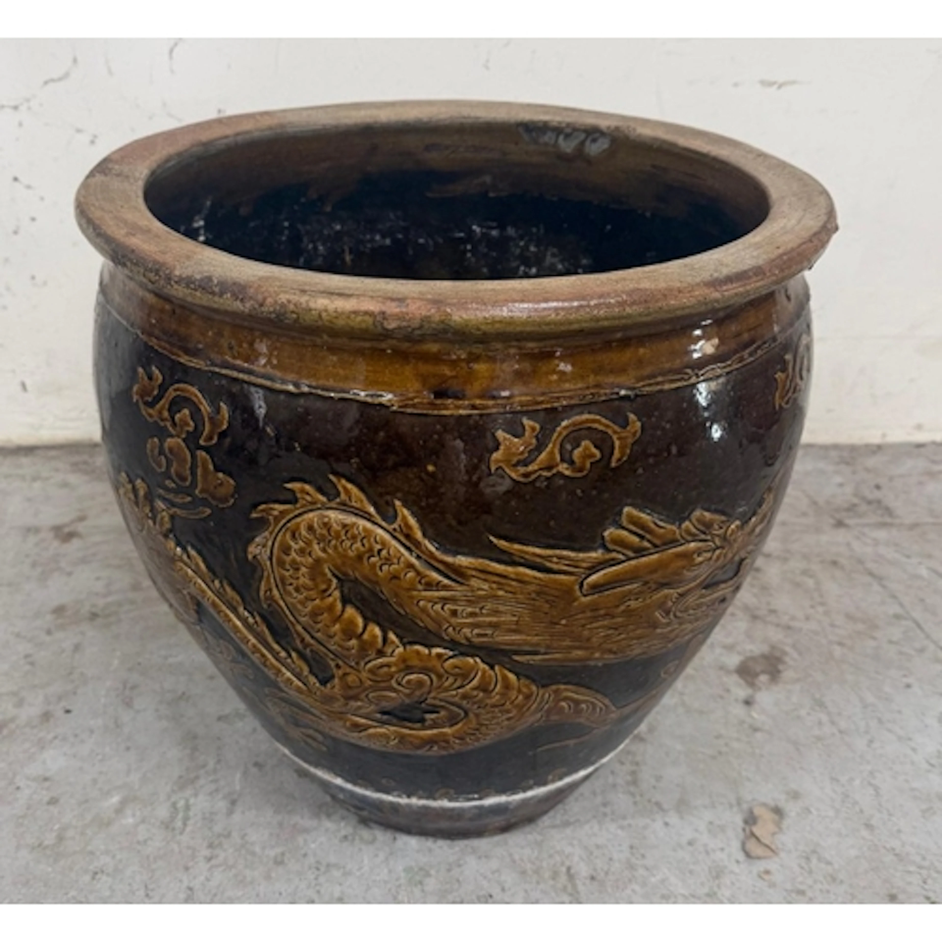 A Chinese brown glazed fish bowl with dragon relief