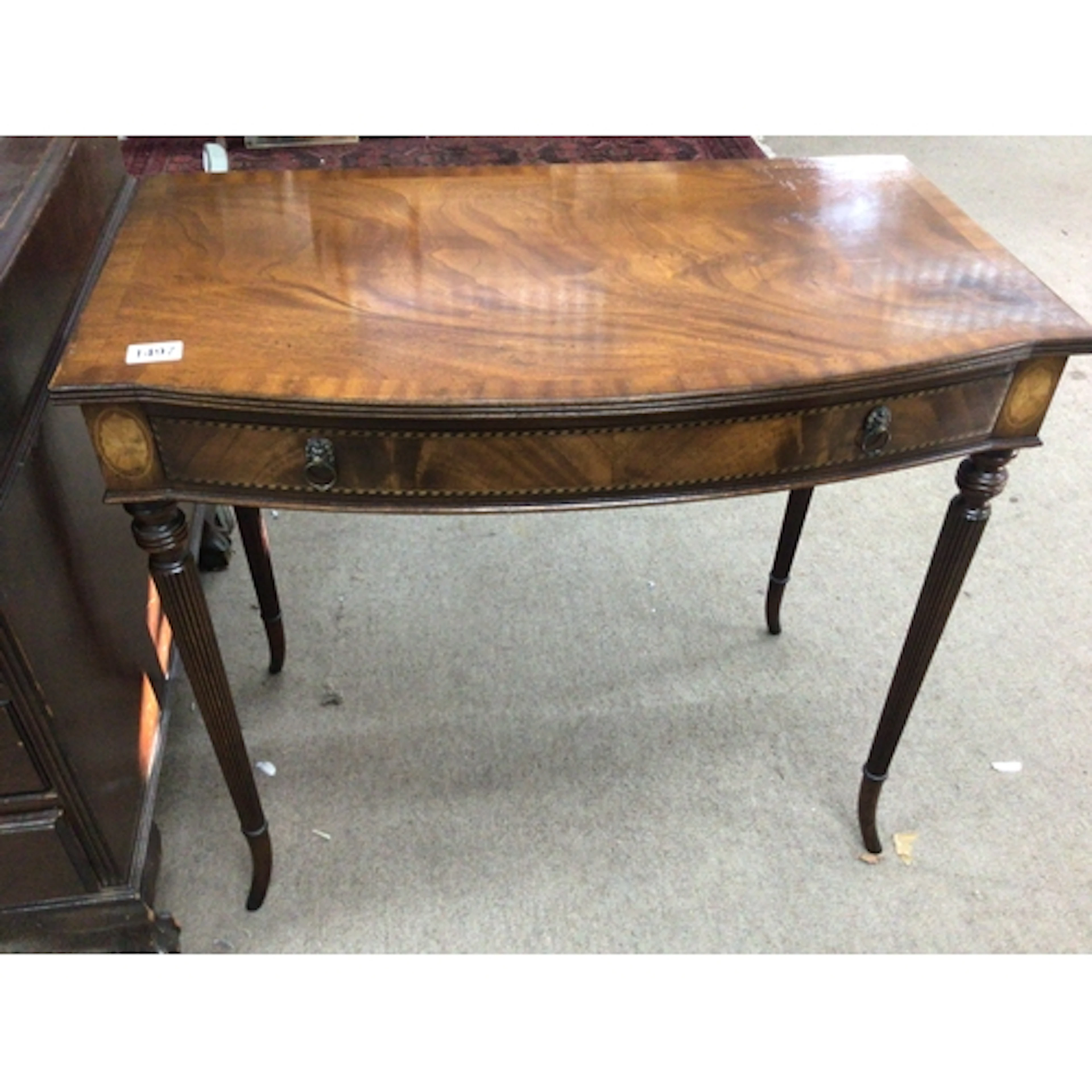 A mahogany side table the cross banded edge above a single d...