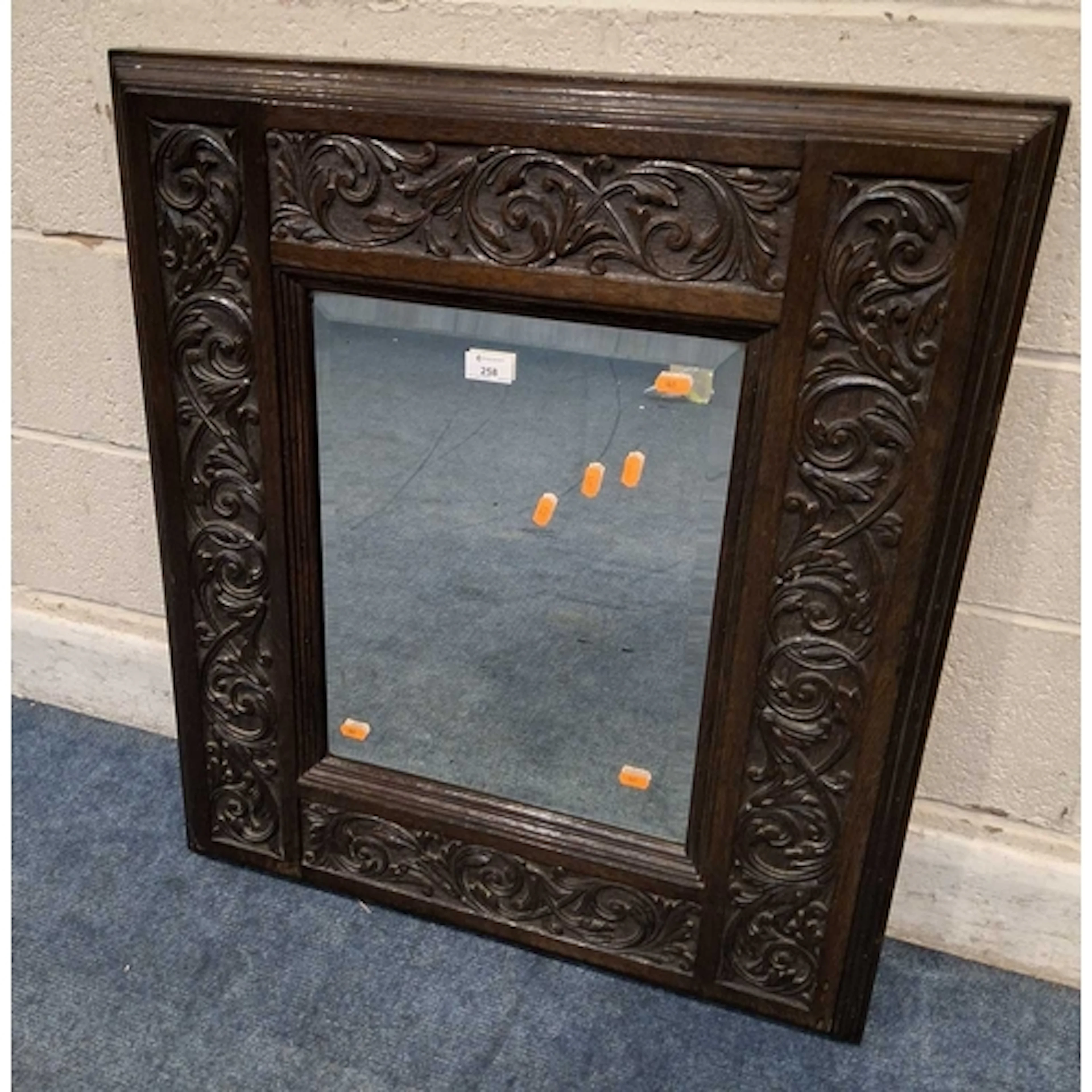 A 20TH CENTURY OAK FRAMED BEVELLED EDGE WALL MIRROR, with fo...