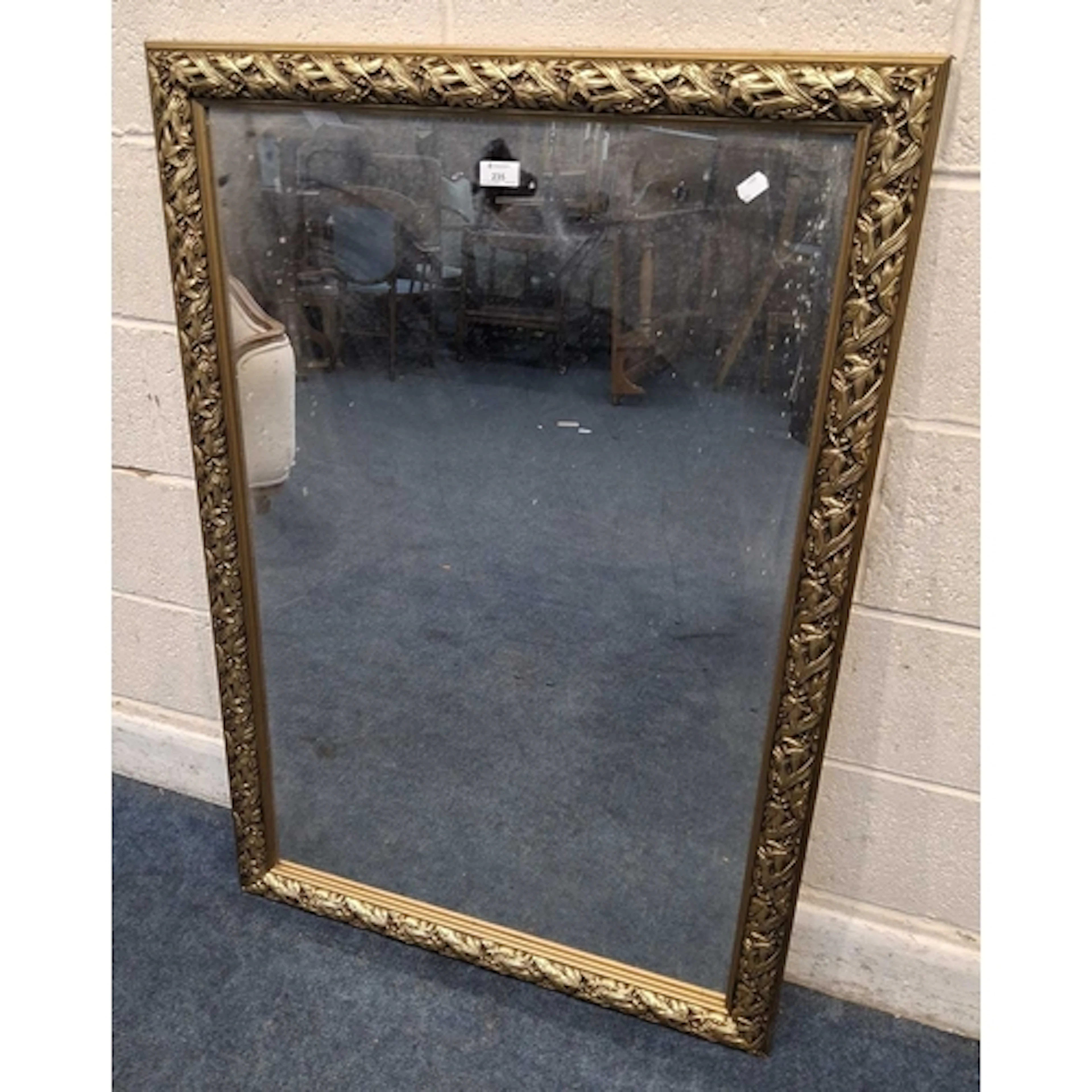 A GILT WOOD RECTANGULAR WALL MIRROR, with foliate details to...