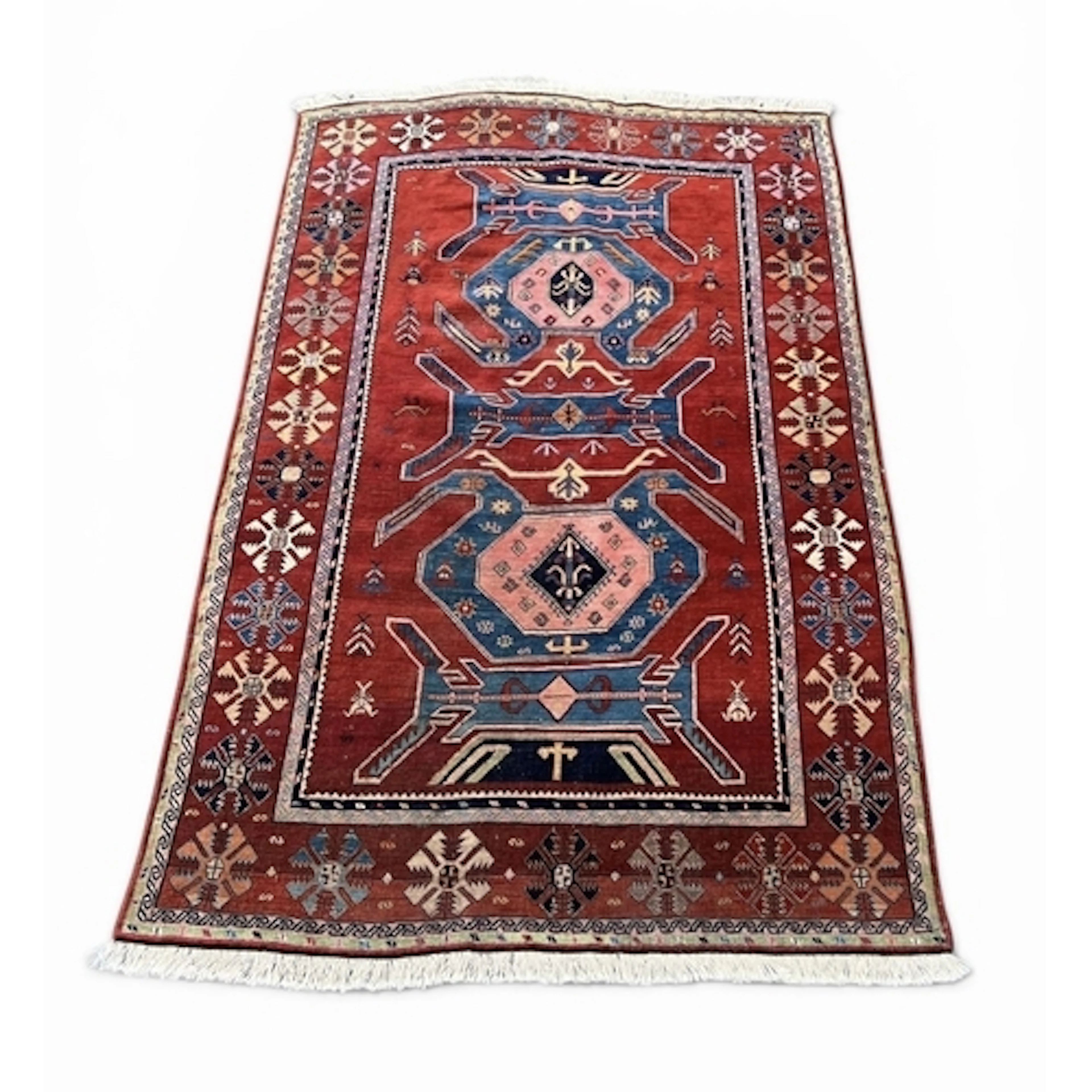 A CAUCASIAN RUG Centred by two blue and pink medallions, res...