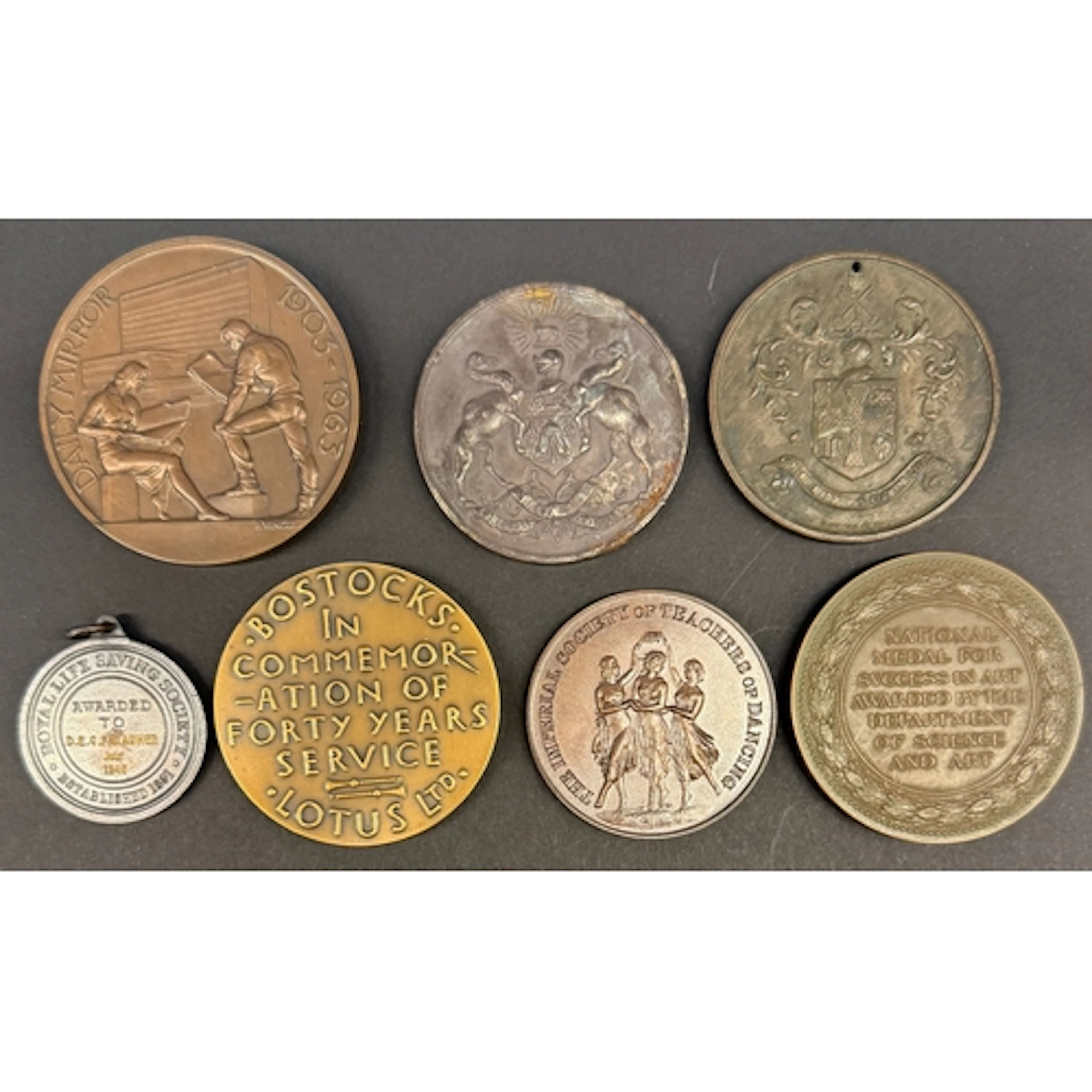 A group of seven long-service, attendance and prize medallio...
