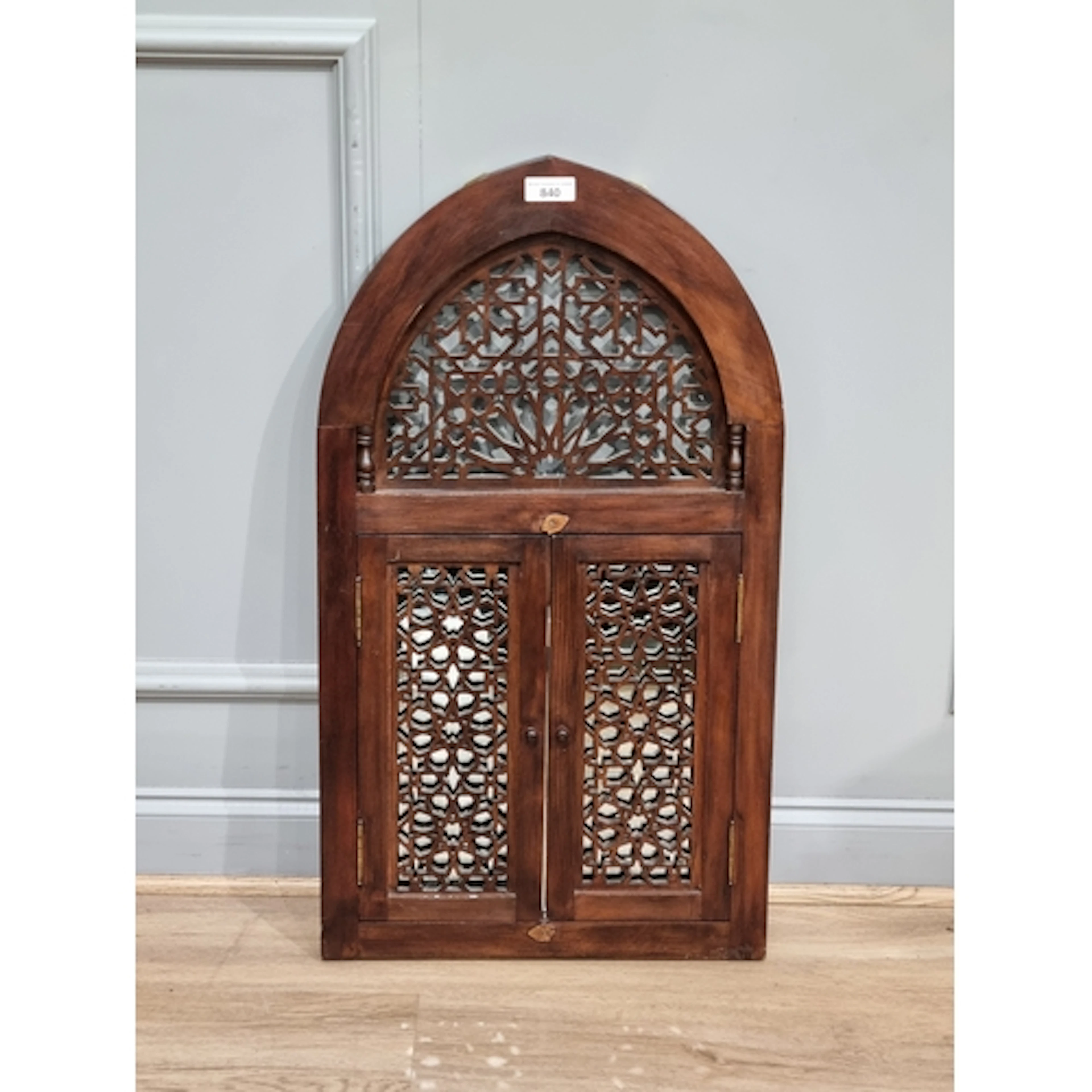 A Moroccan fretwork Mirror with arched top above two doors o...