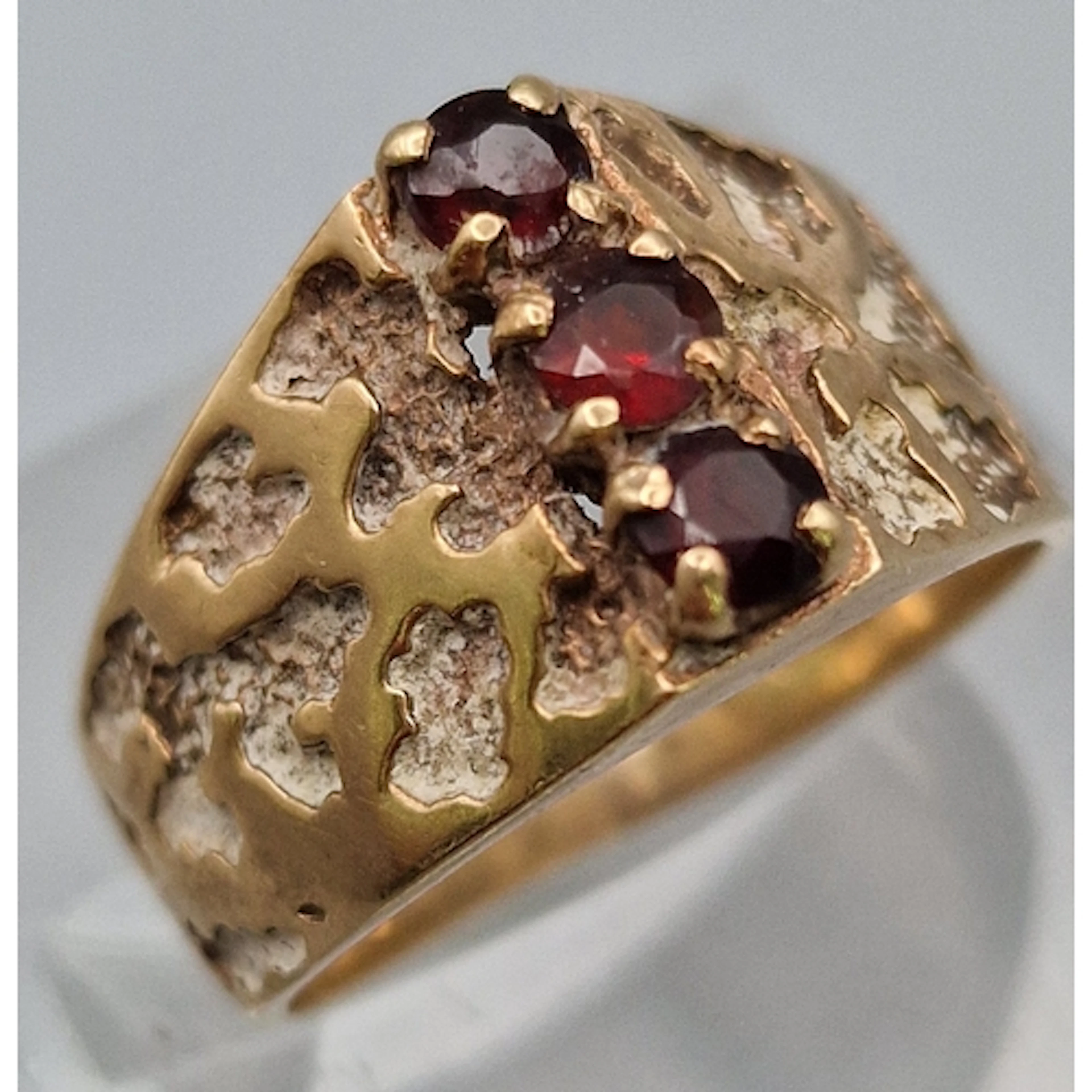 9ct gold garnet three stone textured design dress ring. 3.5g...