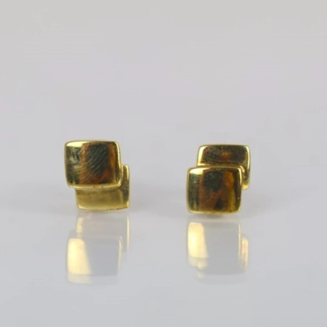 A pair of yellow metal earrings, the plain polished studs of...