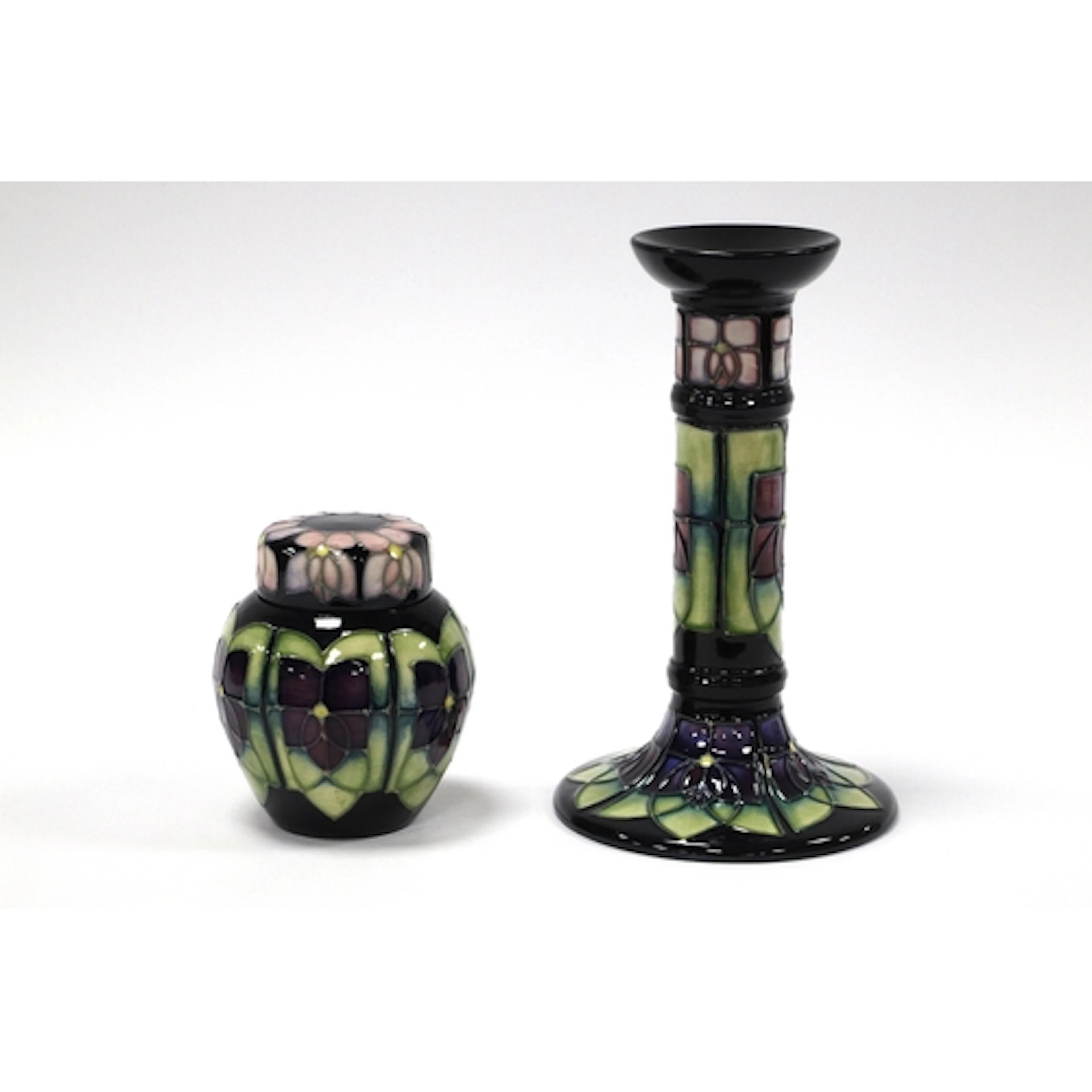 A Moorcroft Pottery Candlestick, painted in the 'Violet' pat...