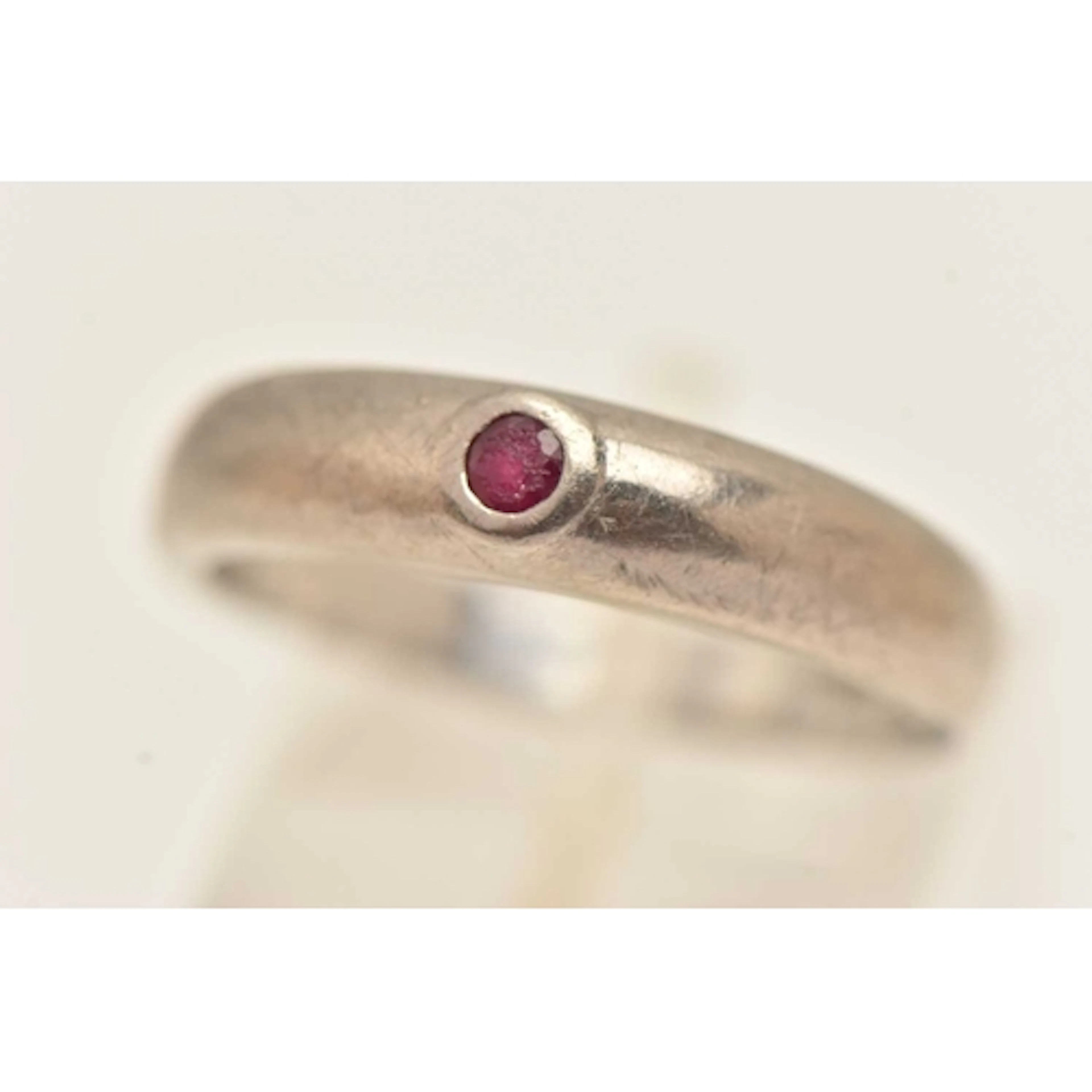 AN 18CT WHITE GOLD RUBY SET RING, small circular cut ruby in...
