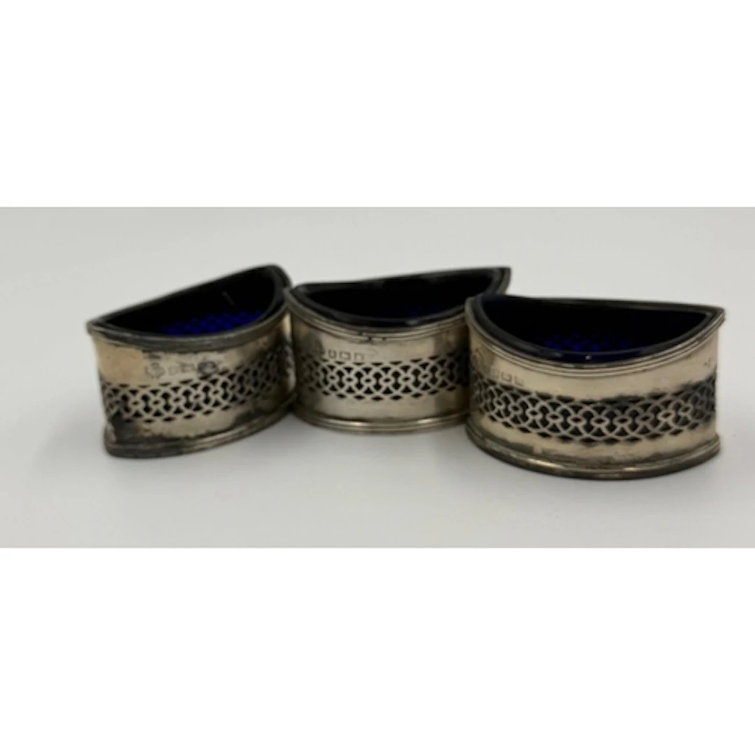 A selection of three silver salts with blue glass liners, ha...
