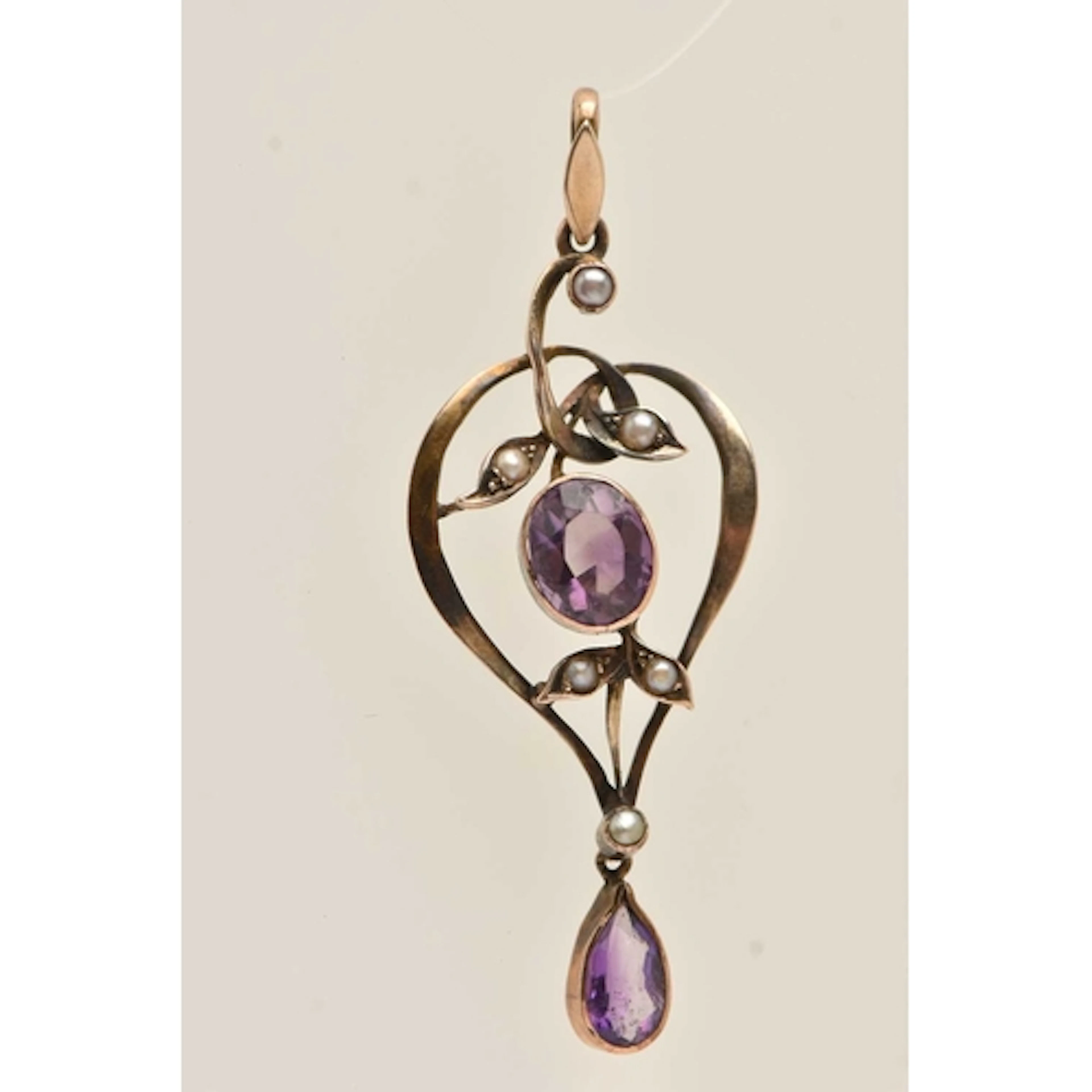 A YELLOW METAL GEM SET LAVALIER PENDANT, open work scrolling...