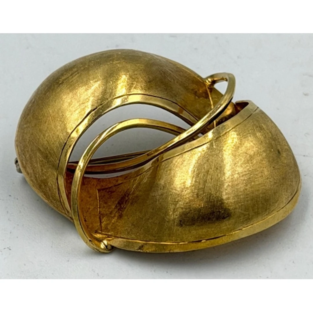 An 18ct brushed finished brooch with swirl design.