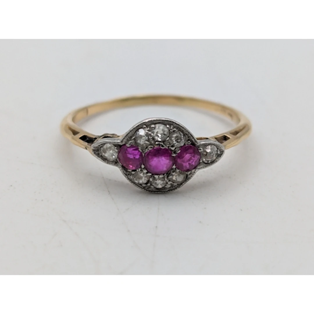A ruby and diamond yellow and white metal ring, tested as 18...