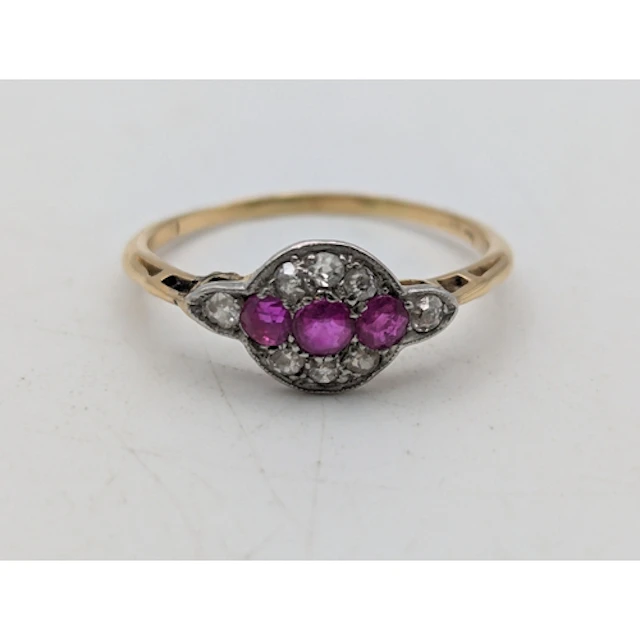 A ruby and diamond yellow and white metal ring, tested as 18...