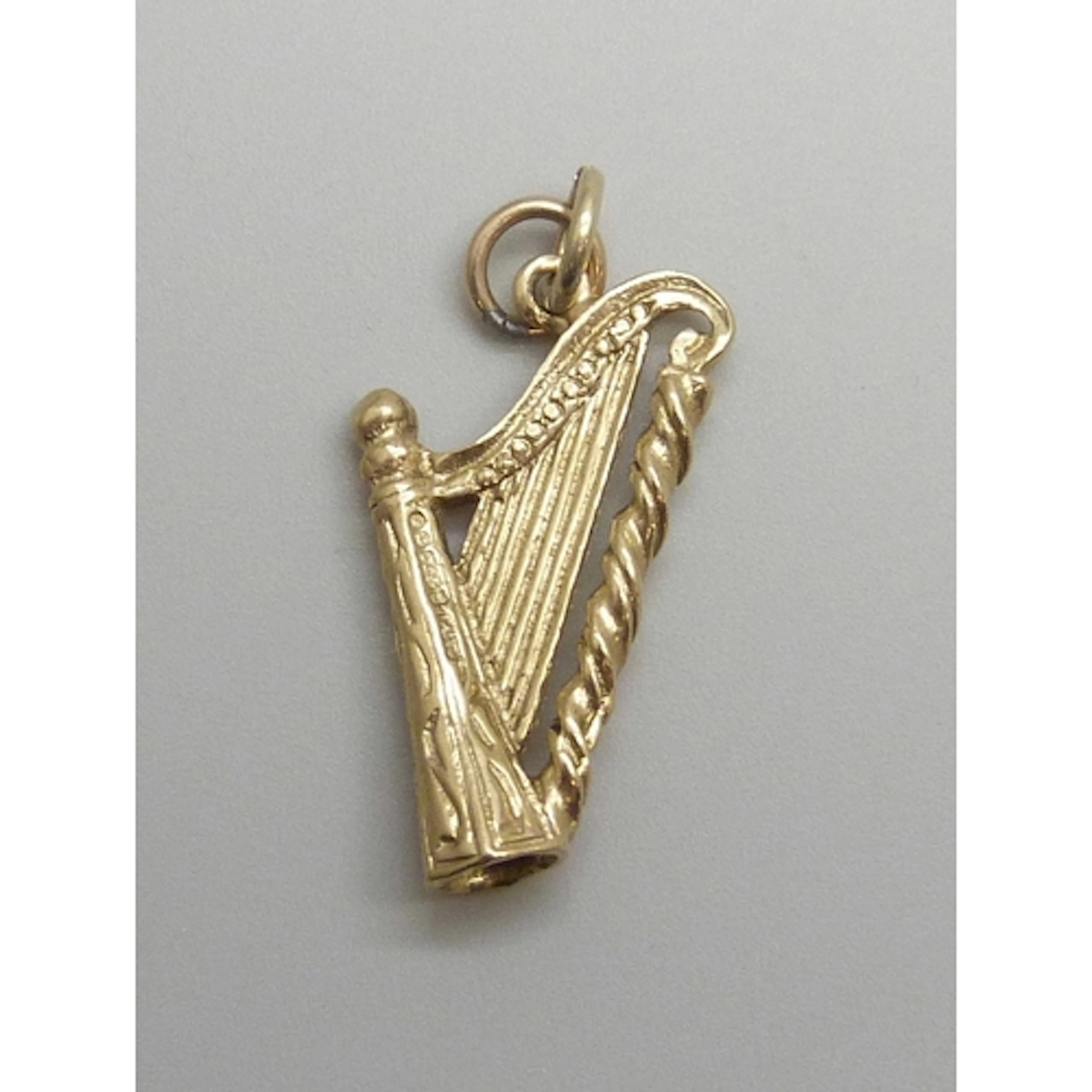 A 9ct gold charm in the form of a harp, hallmarked, 2.1g, 3c...