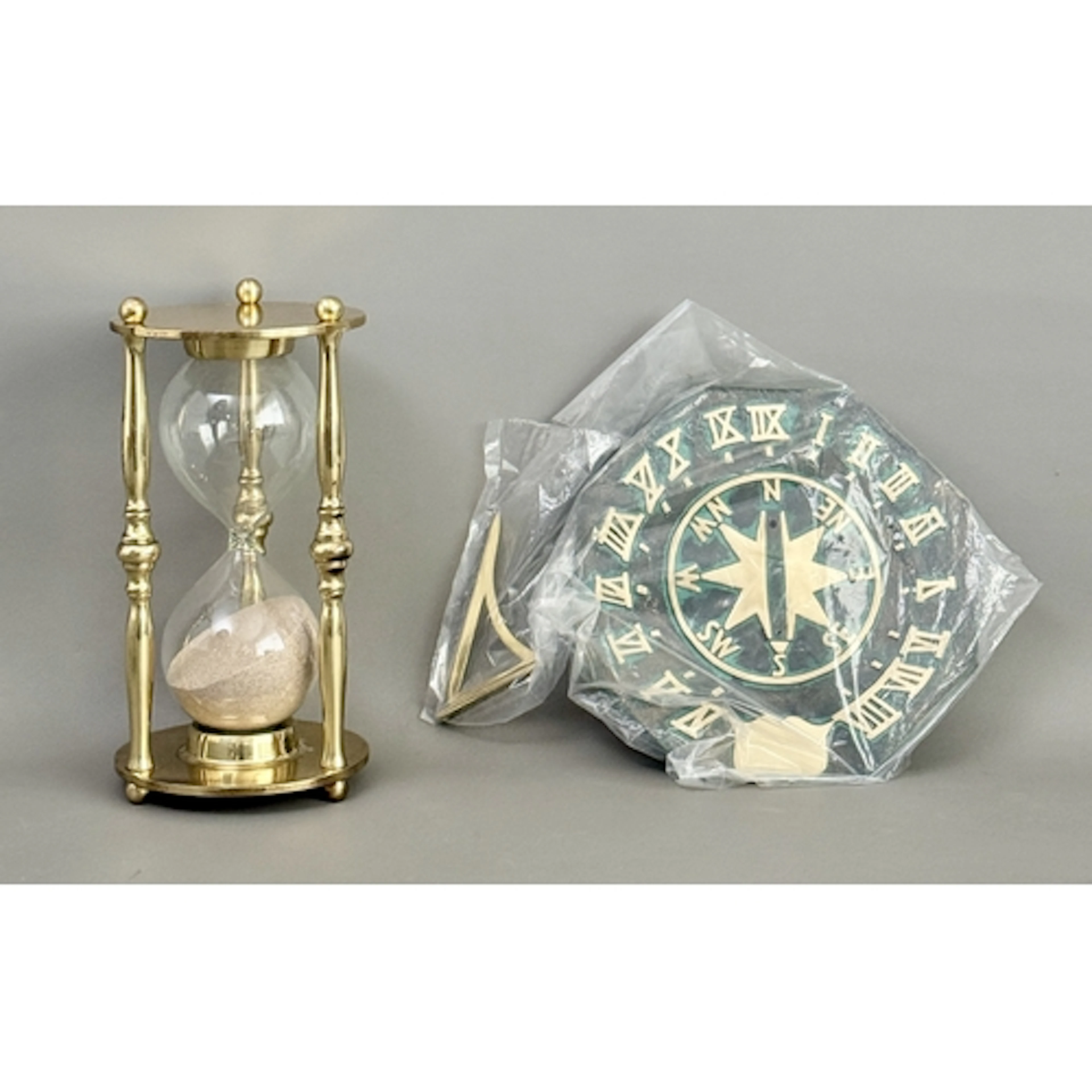 A large brass and glass hourglass - 25cm high; together with...