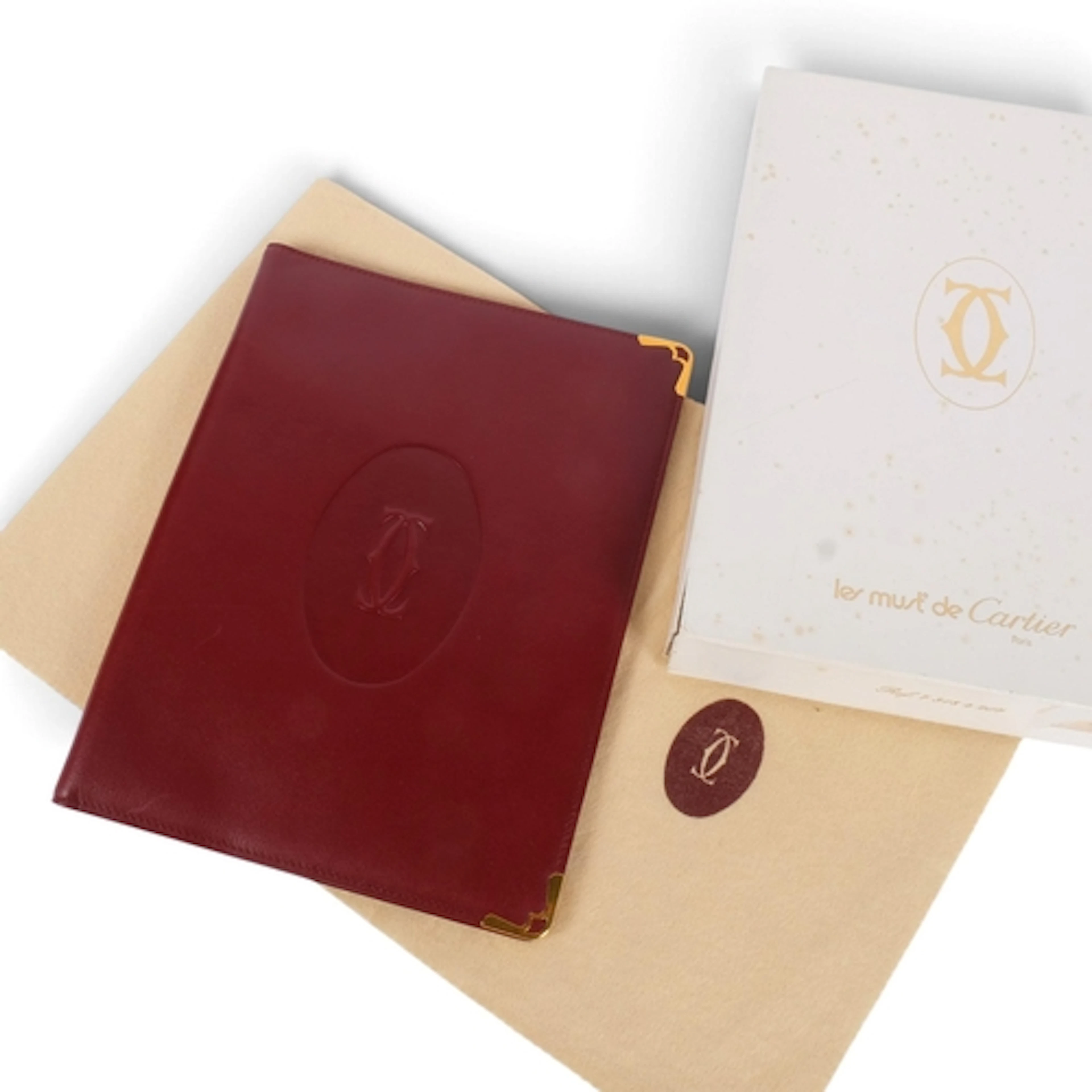 Les Must De Cartier, Paris, a burgundy leather notebook, age...