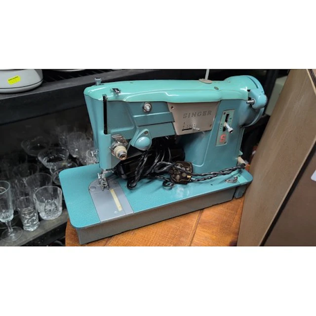 Singer electric sewing machine in turquoise and grey, with a...