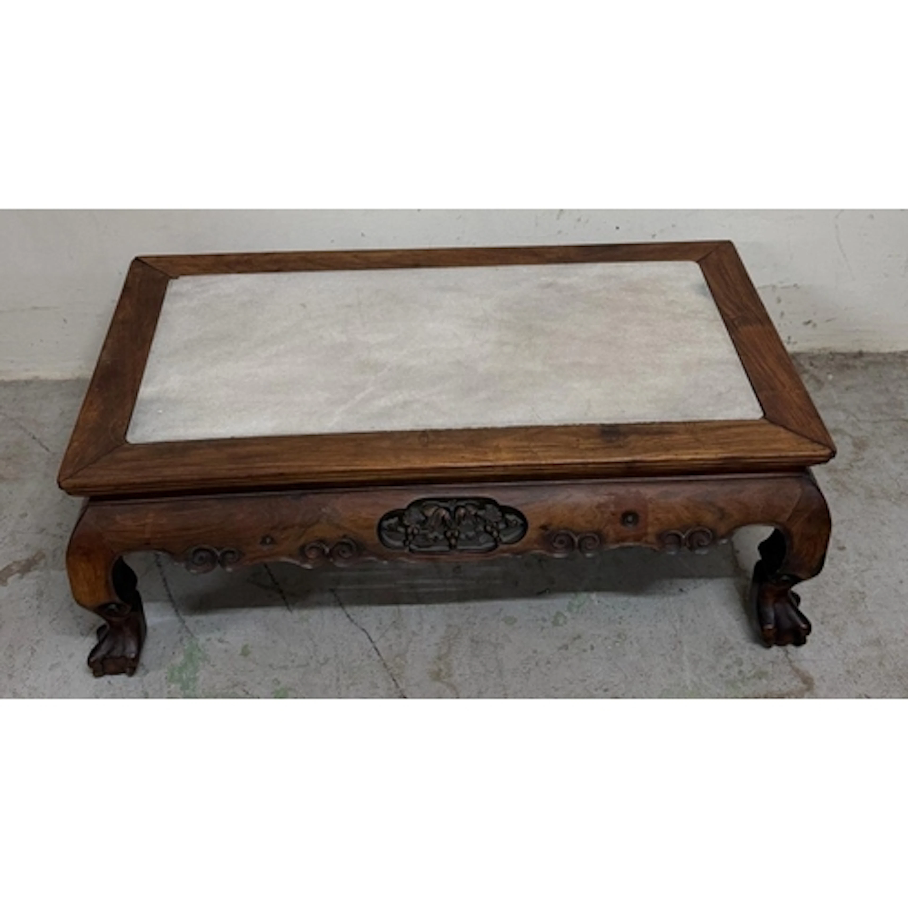 A white marble topped hardwood coffee table on claw and ball...