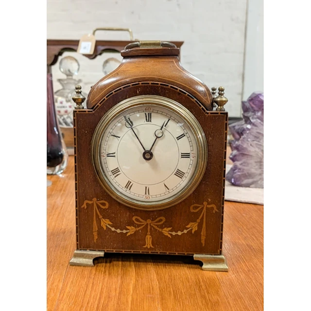 A small Edwardian inlaid mahogany mantel clock with brass ca...