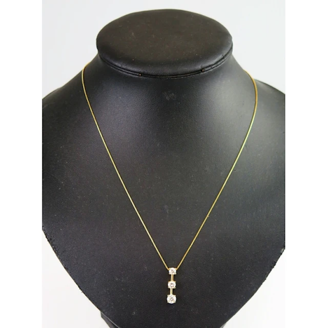 A diamond three stone pendant in a 14K yellow gold setting a...