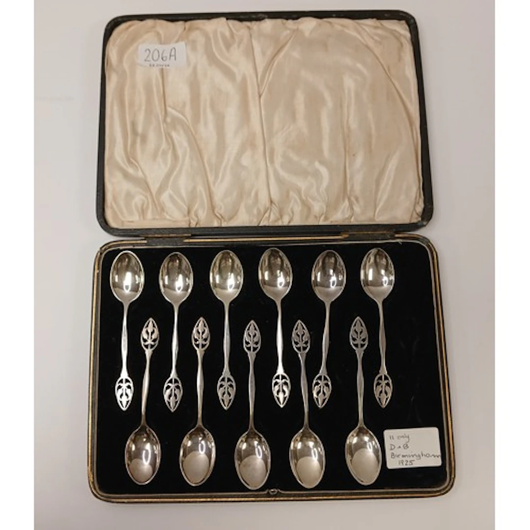 Set of eleven Silver tea spoons with pierced handles, in fit...