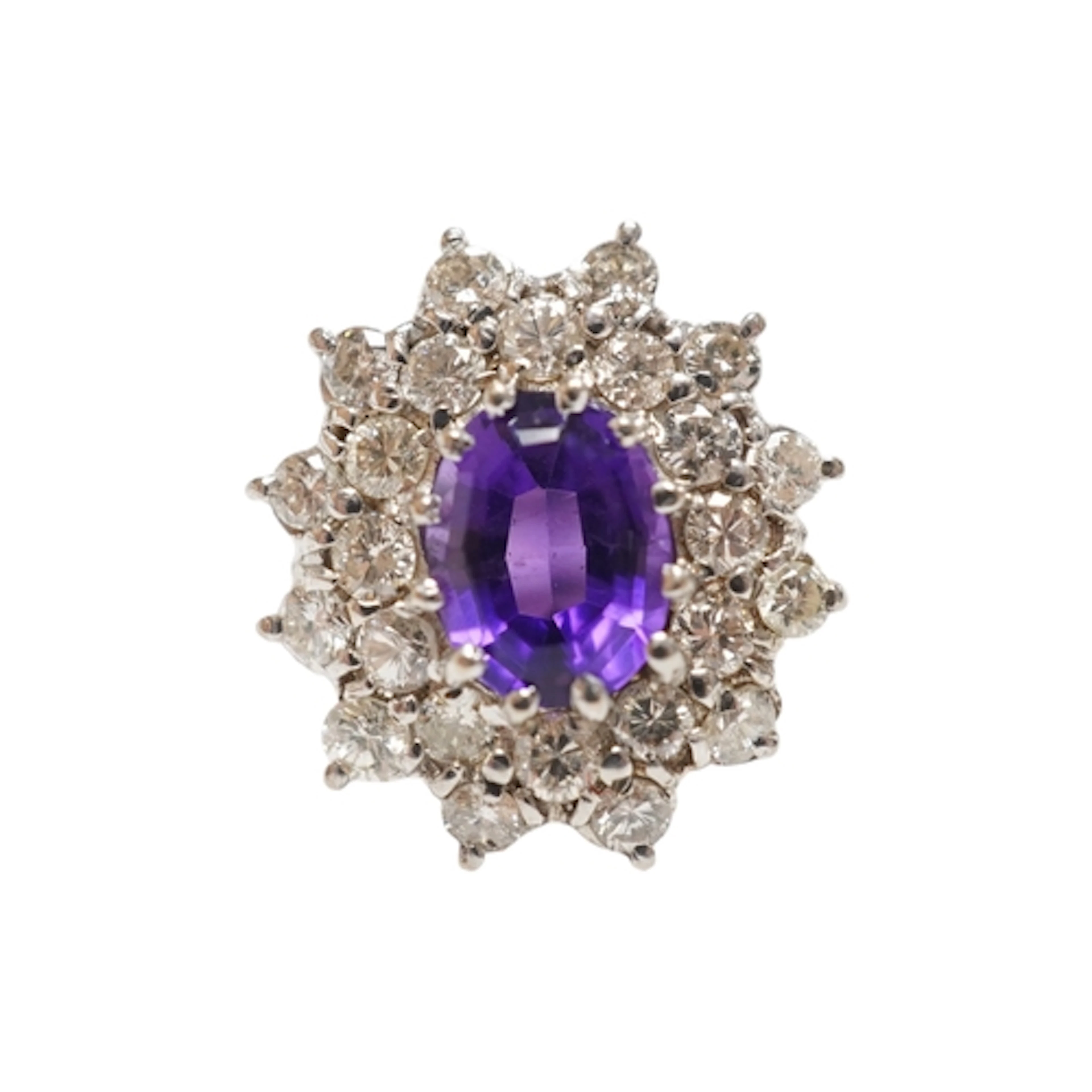 An amethyst and diamond ring, claw-set with an oval amethyst...