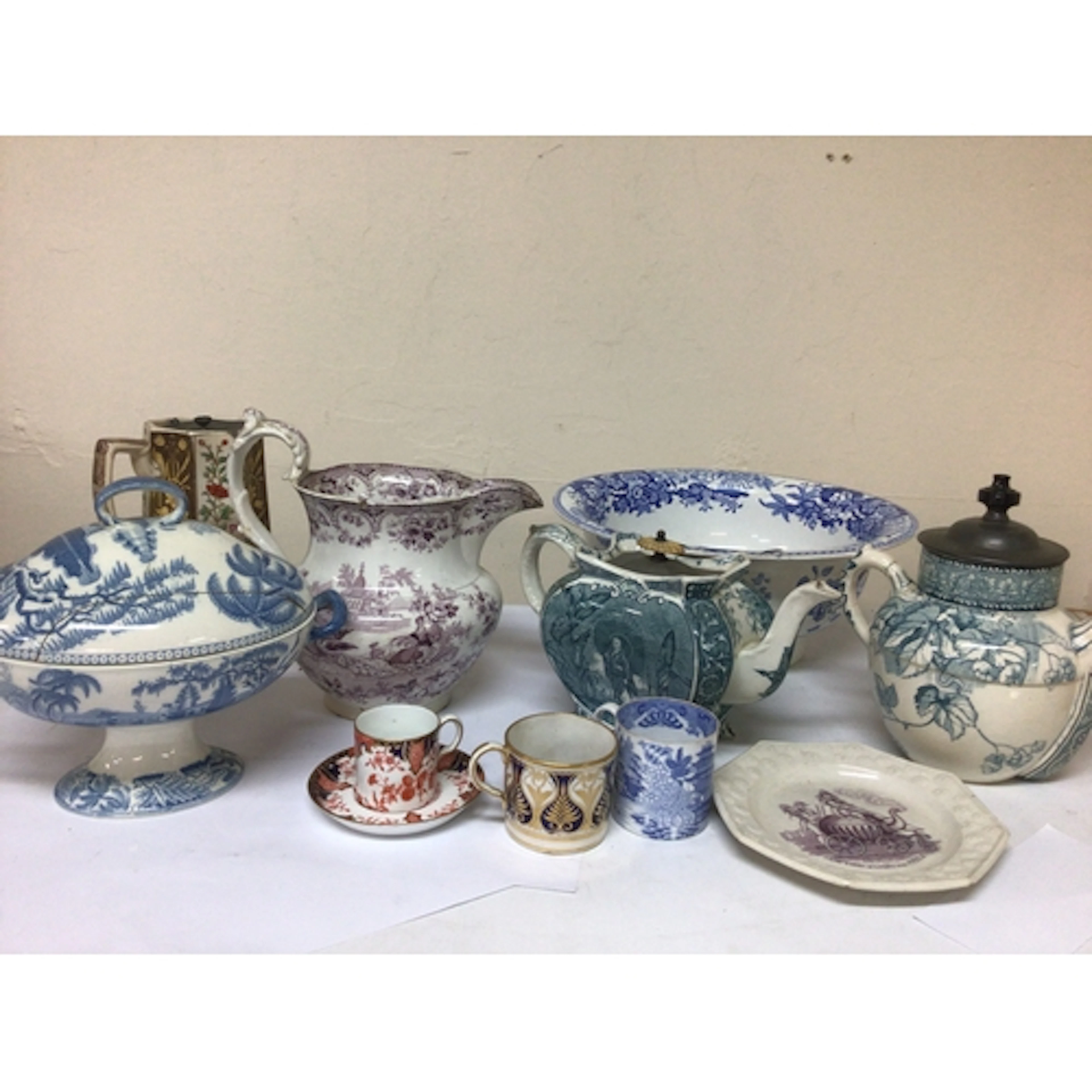 A box containing Victorian ceramic tea pots a 19th cen...
