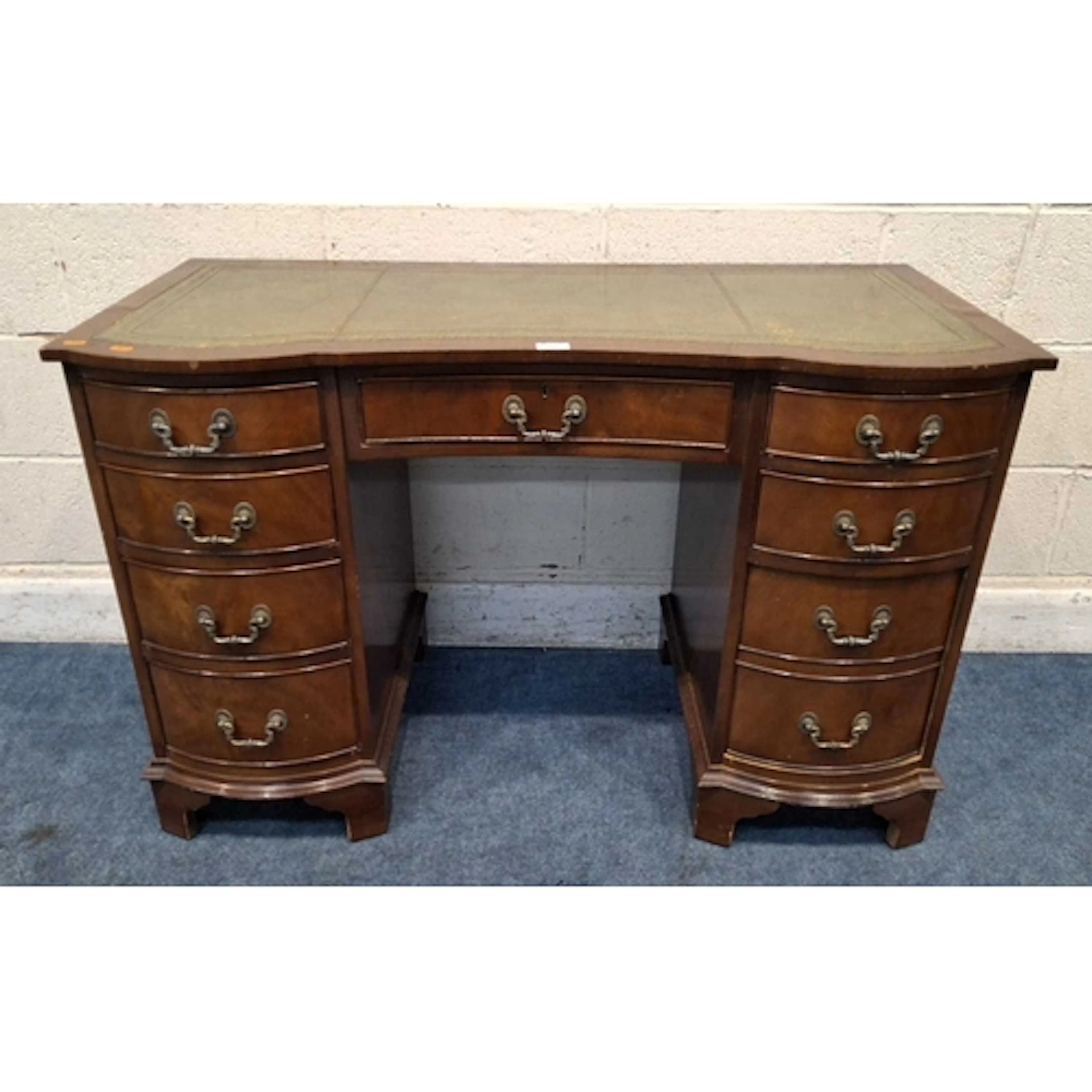 A REPRODUCTION MAHOGANY DOUBLE BOW FRONT DESK, with a green ...