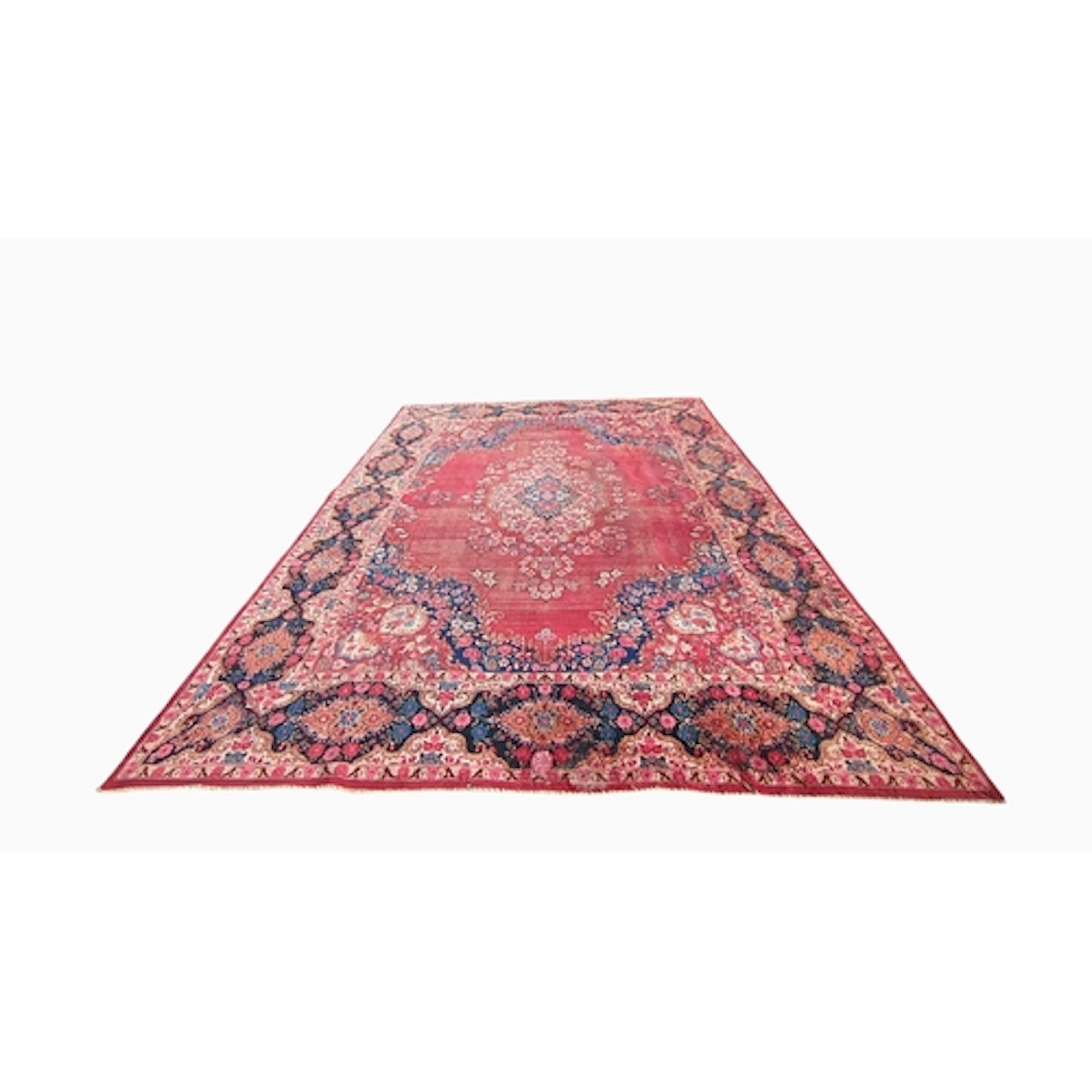 Large Persian-style rug with a crimson field centred by a fl...