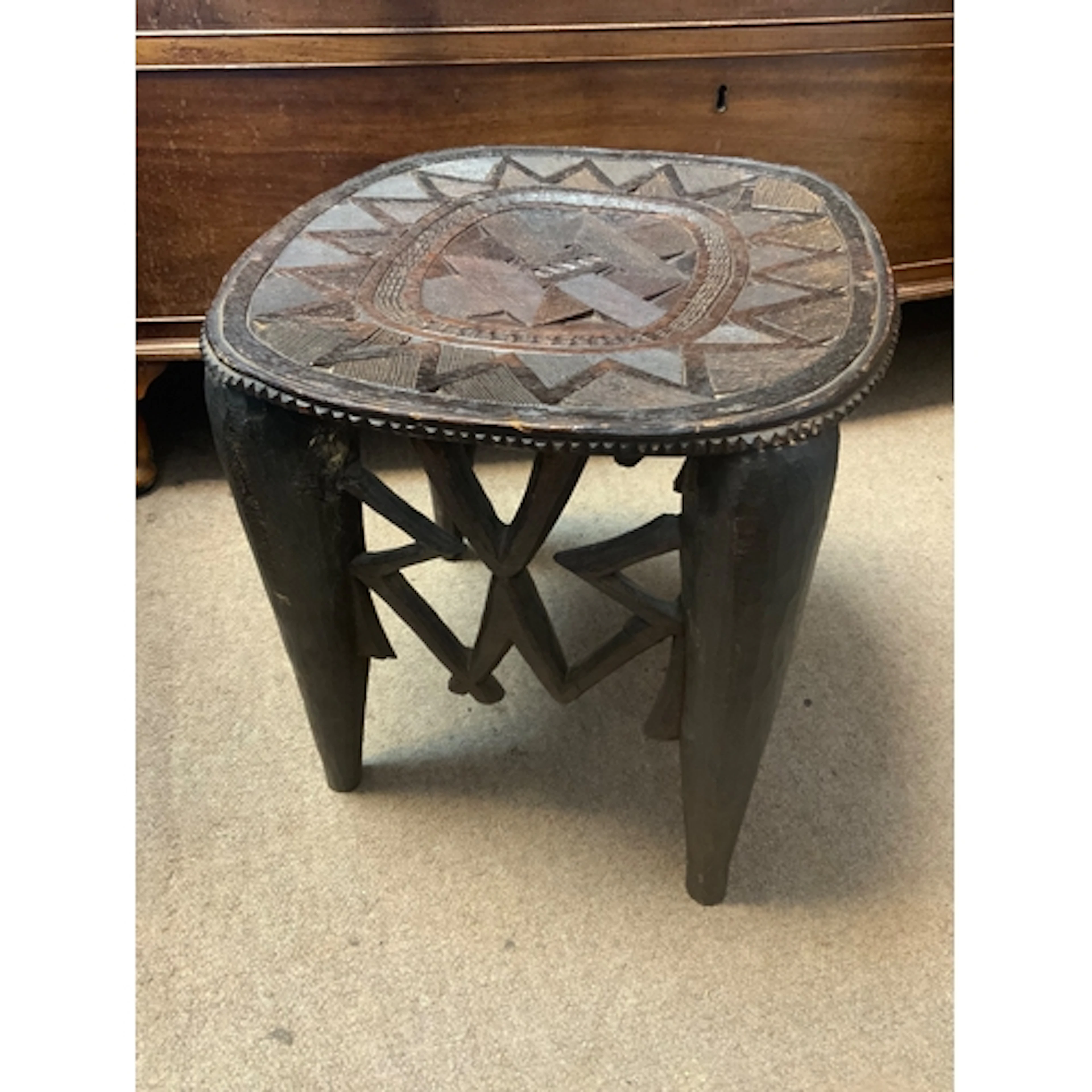 A vintage hand carved Nupe stool from Nigeria with intricate...
