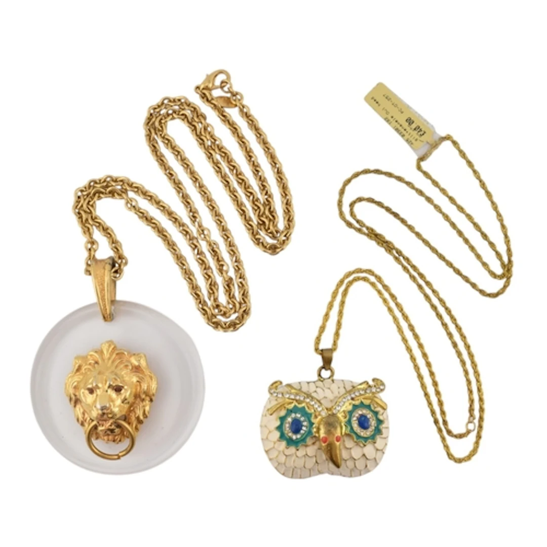 Two gold tone pendant necklaces strung with animal pendants....