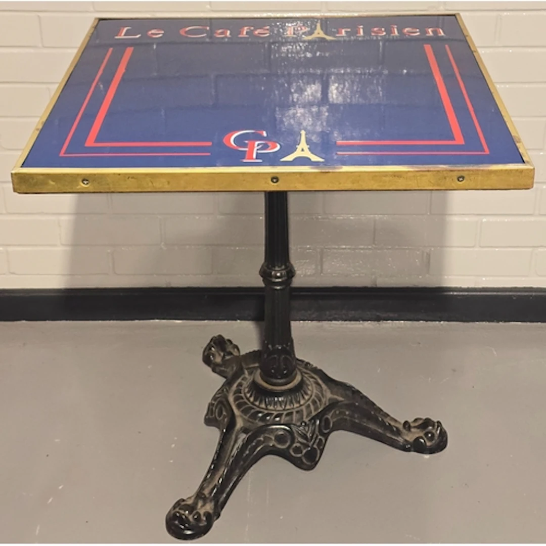 A vintage bistro table resting on heavy antique cast iron ba...