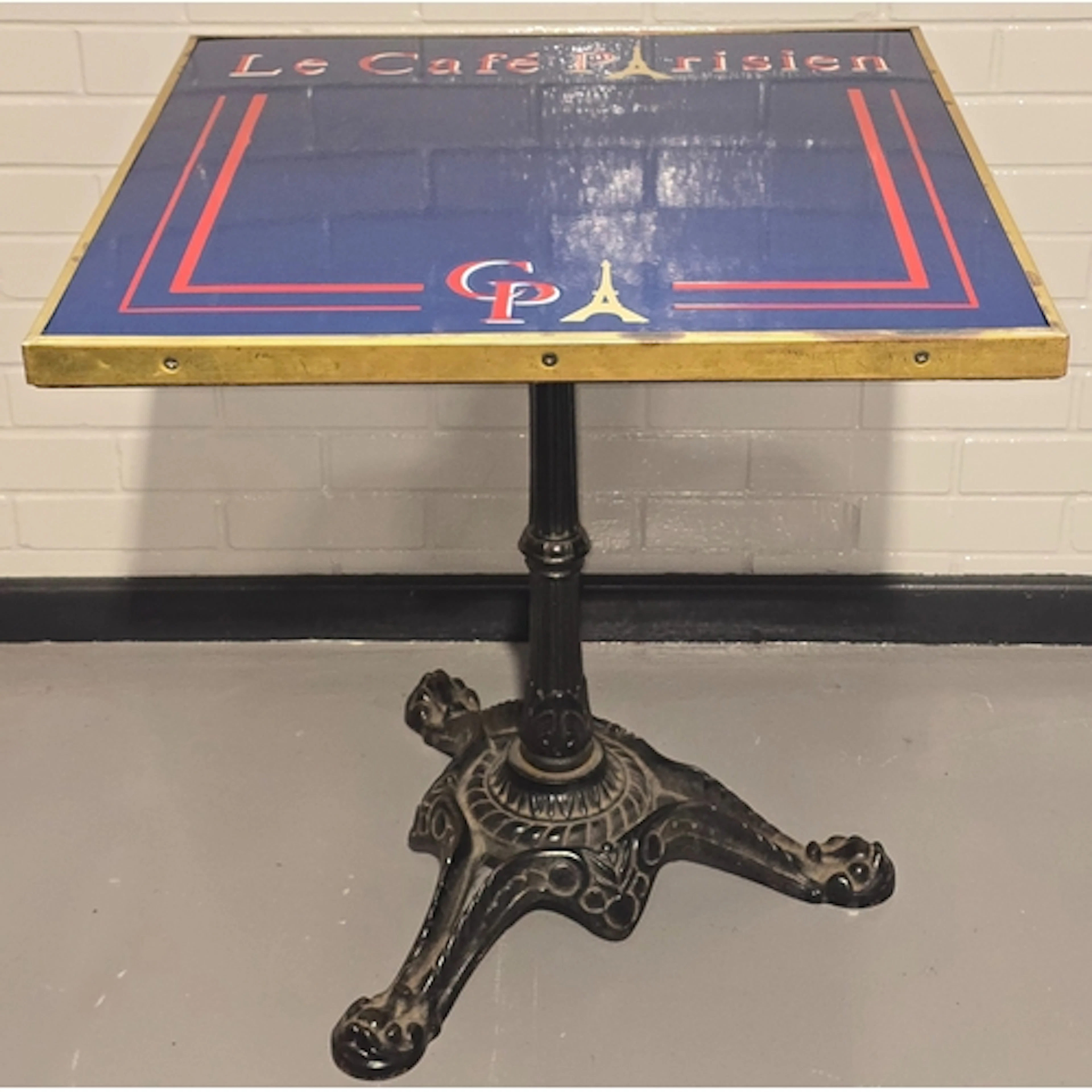 A vintage bistro table resting on heavy antique cast iron ba...