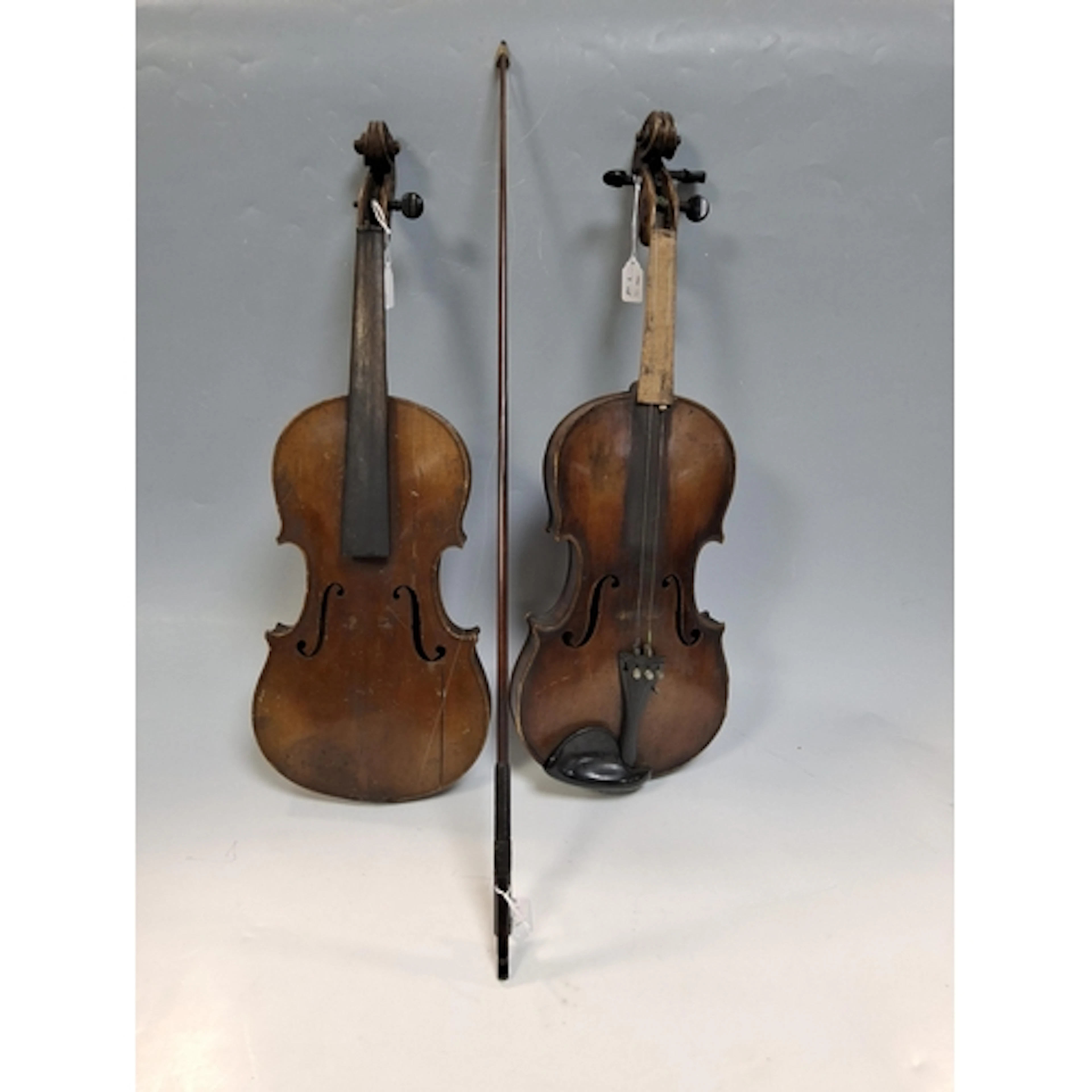 A GROUP CONSISTING OF TWO VIOLINS AND A BOW, both violins ar...