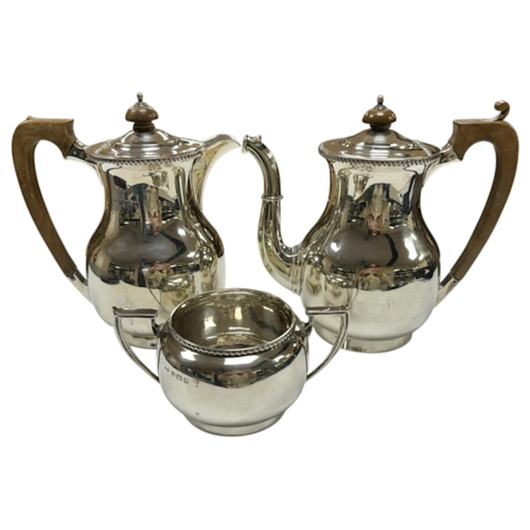 A George VI silver coffee pot, hot water jug and matching su...