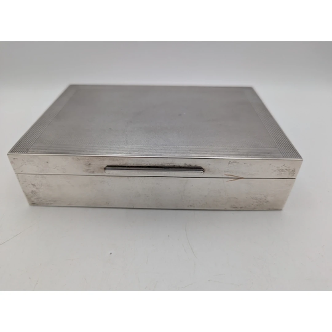 A shallow silver cigarette box of rectangular form with a de...