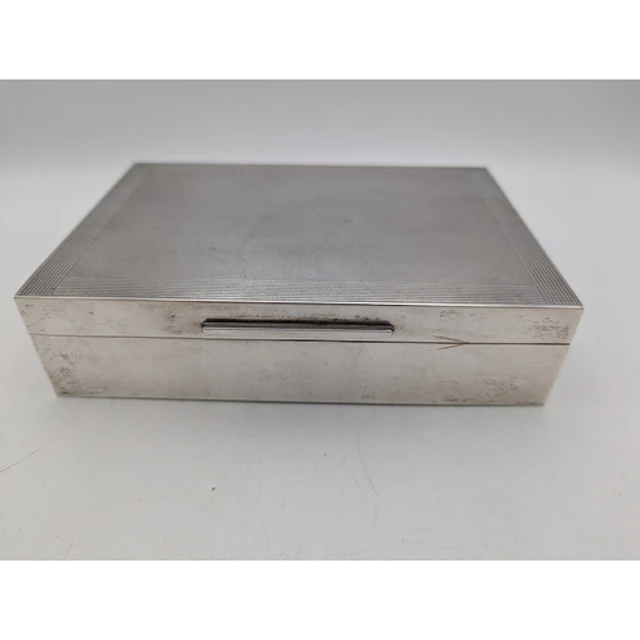 A shallow silver cigarette box of rectangular form with a de...