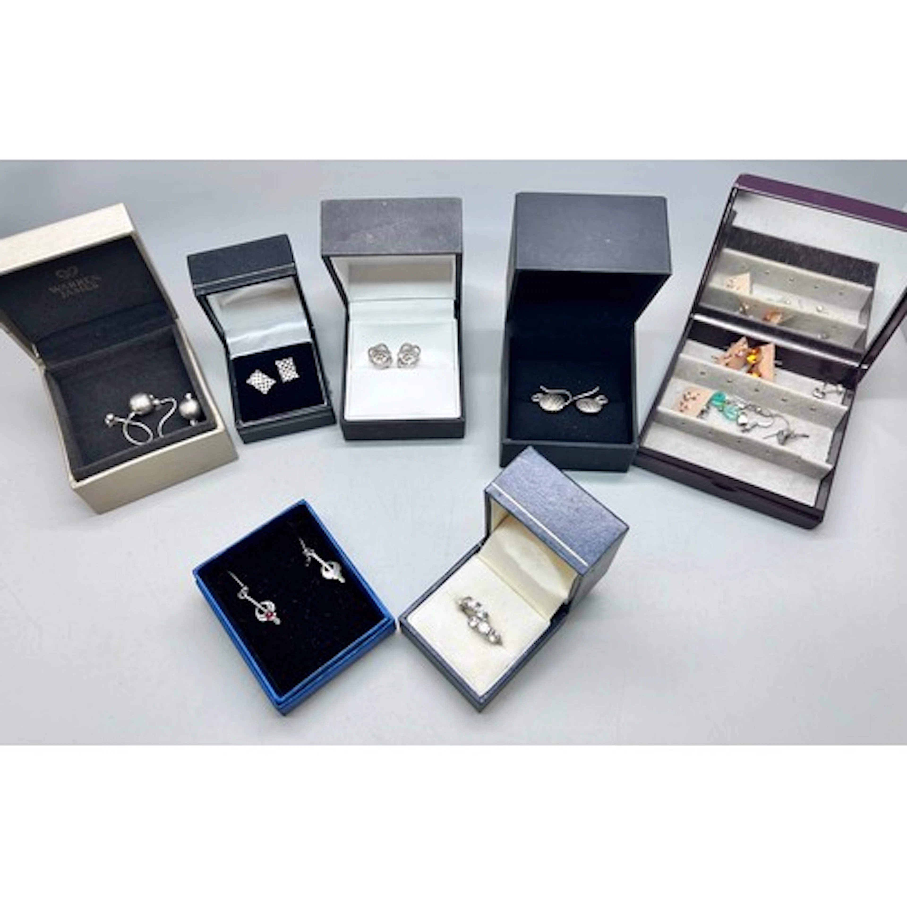 Twelve pairs of silver and white metal earrings