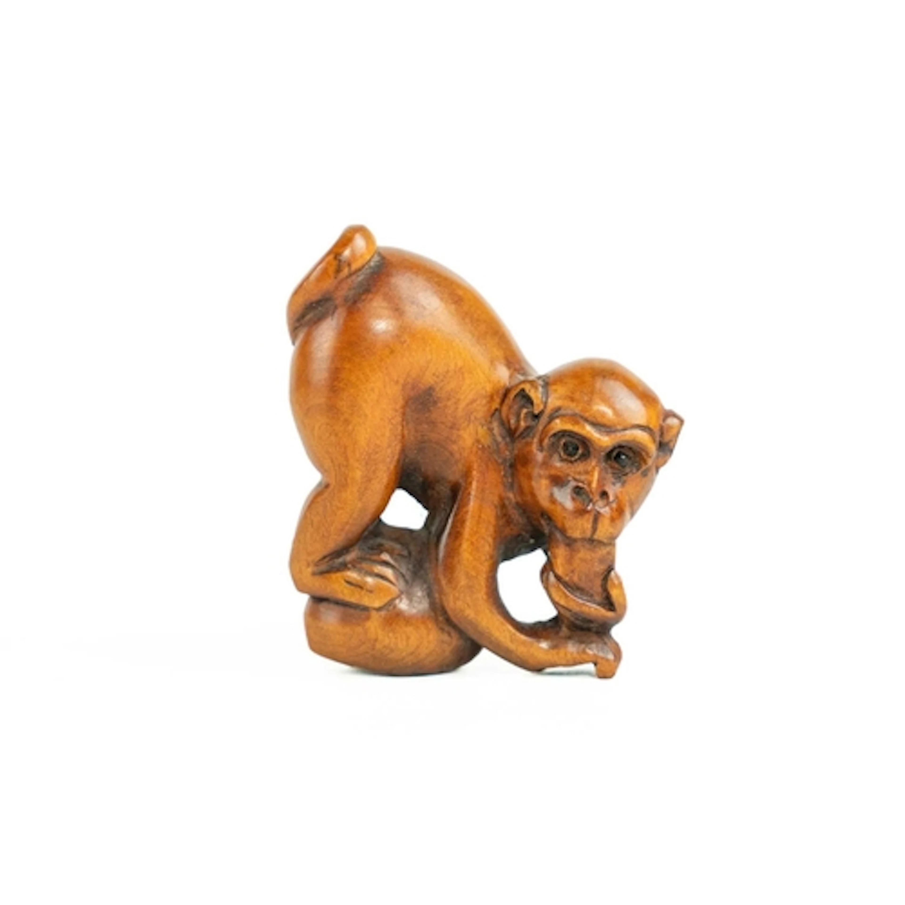 A carved monkey netsuke. Boxwood, with character marks to th...