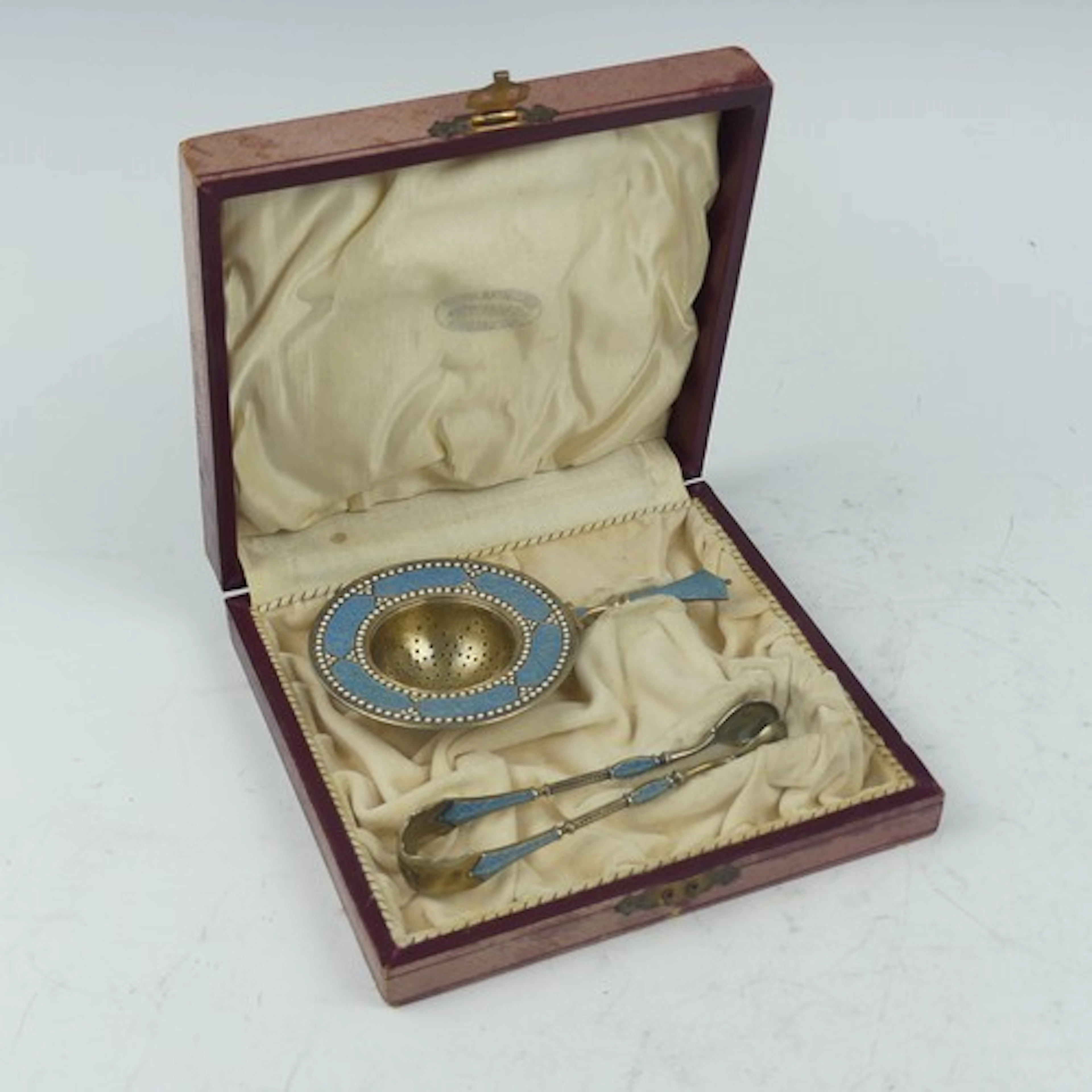 David Andersen; A silver gilt and enamel Tea Strainer and Su...