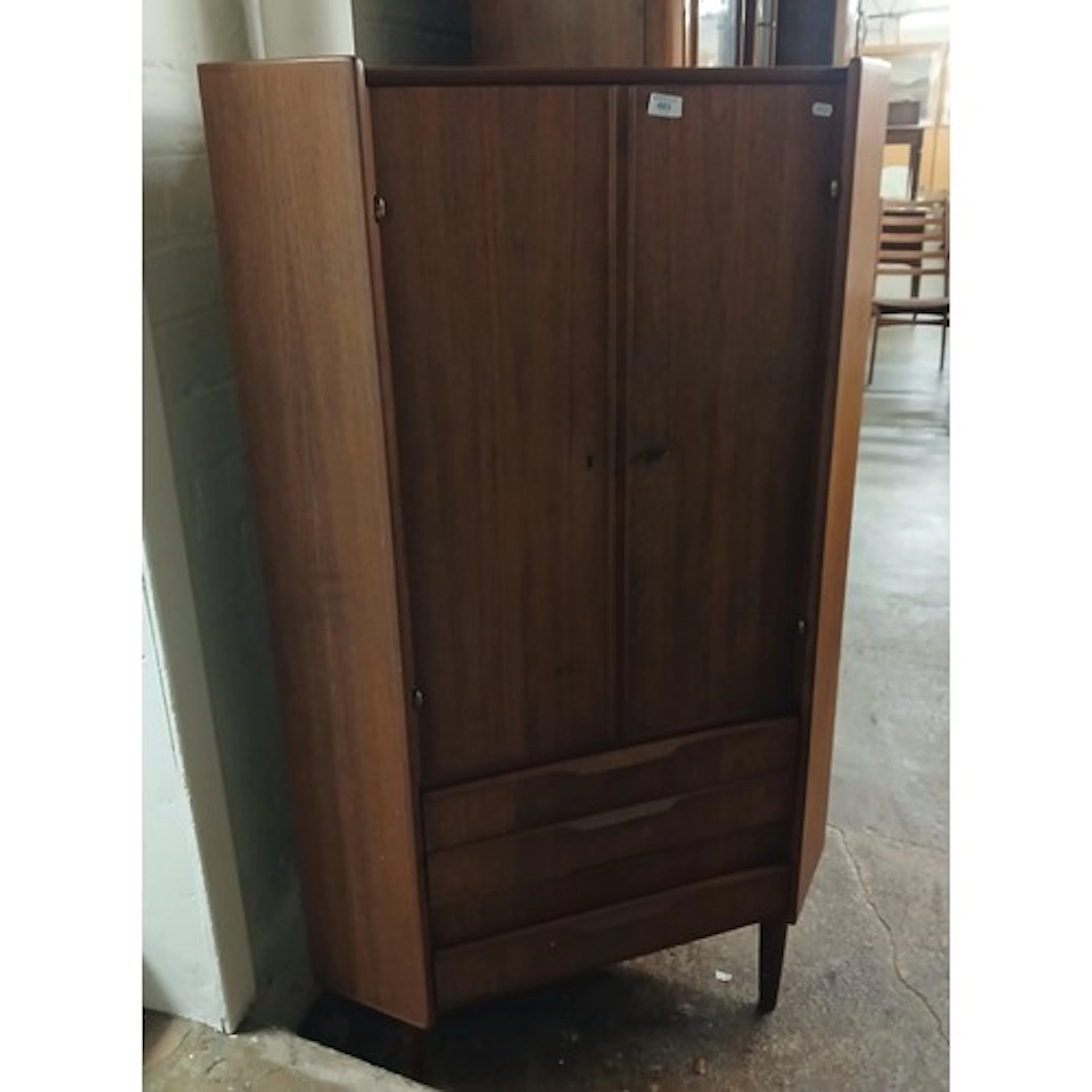 Vintage teak corner unit enclosed by pair of doors over thre...