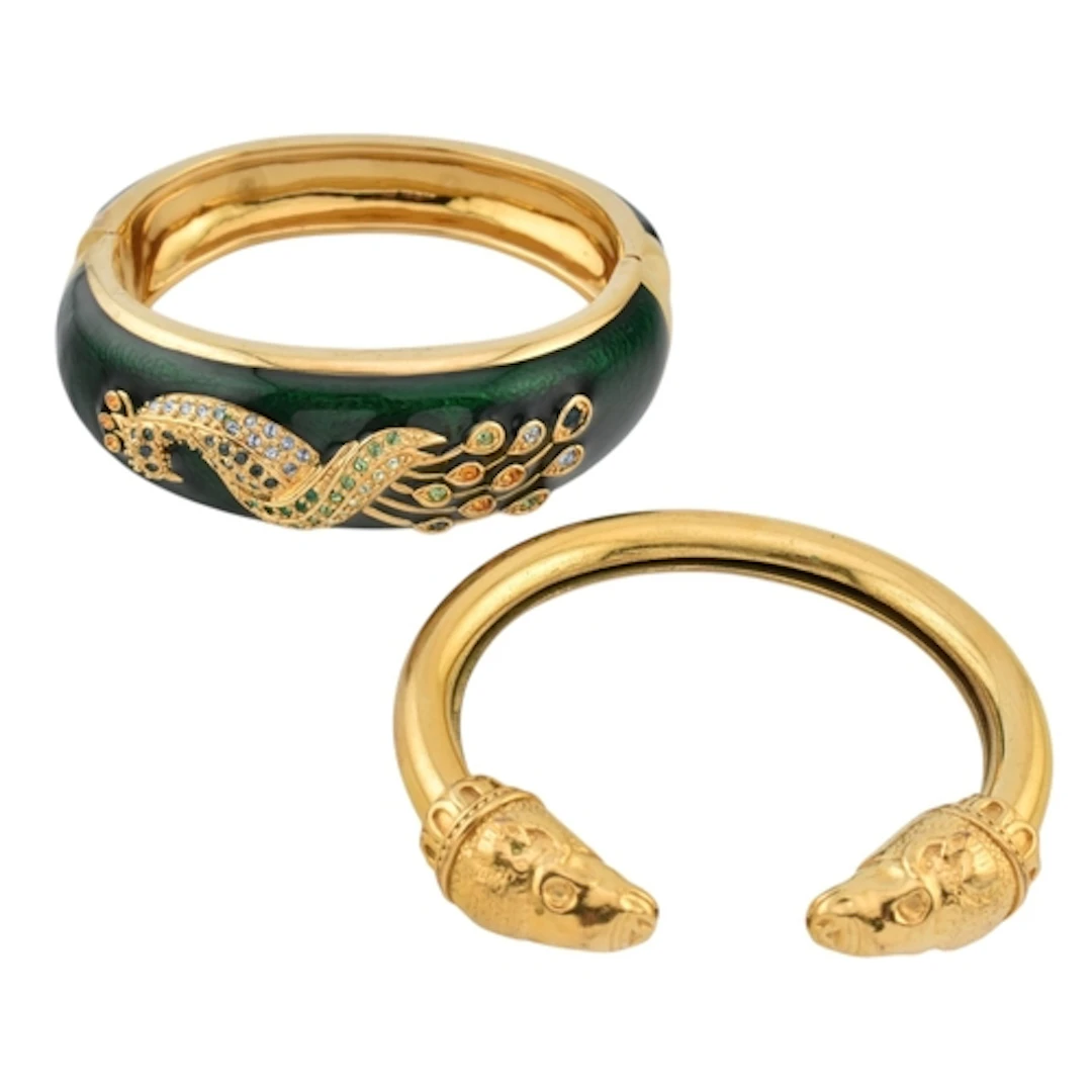Two gold tone bangles. The bangles to include a green enamel...