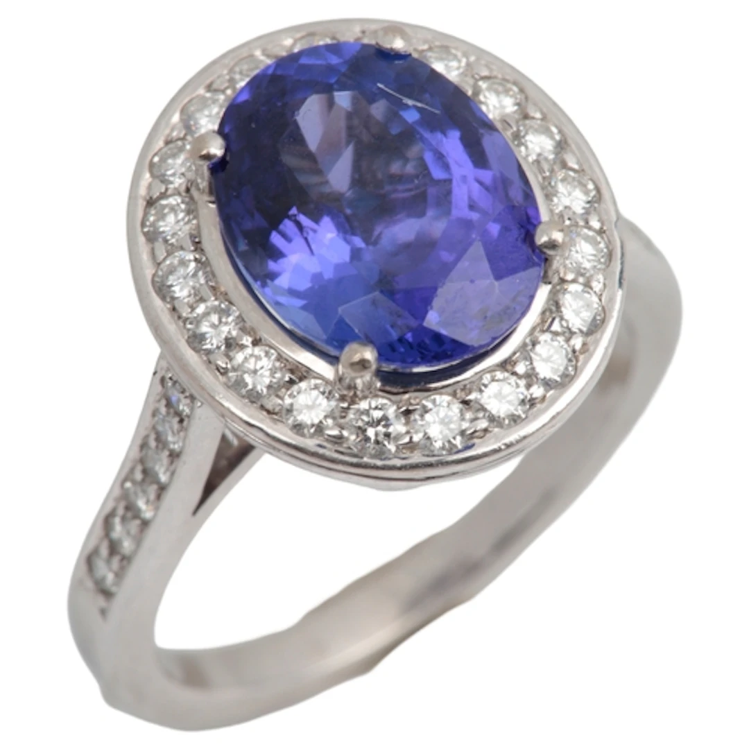 A tanzanite and diamond cluster ring, claw-set with an oval ...