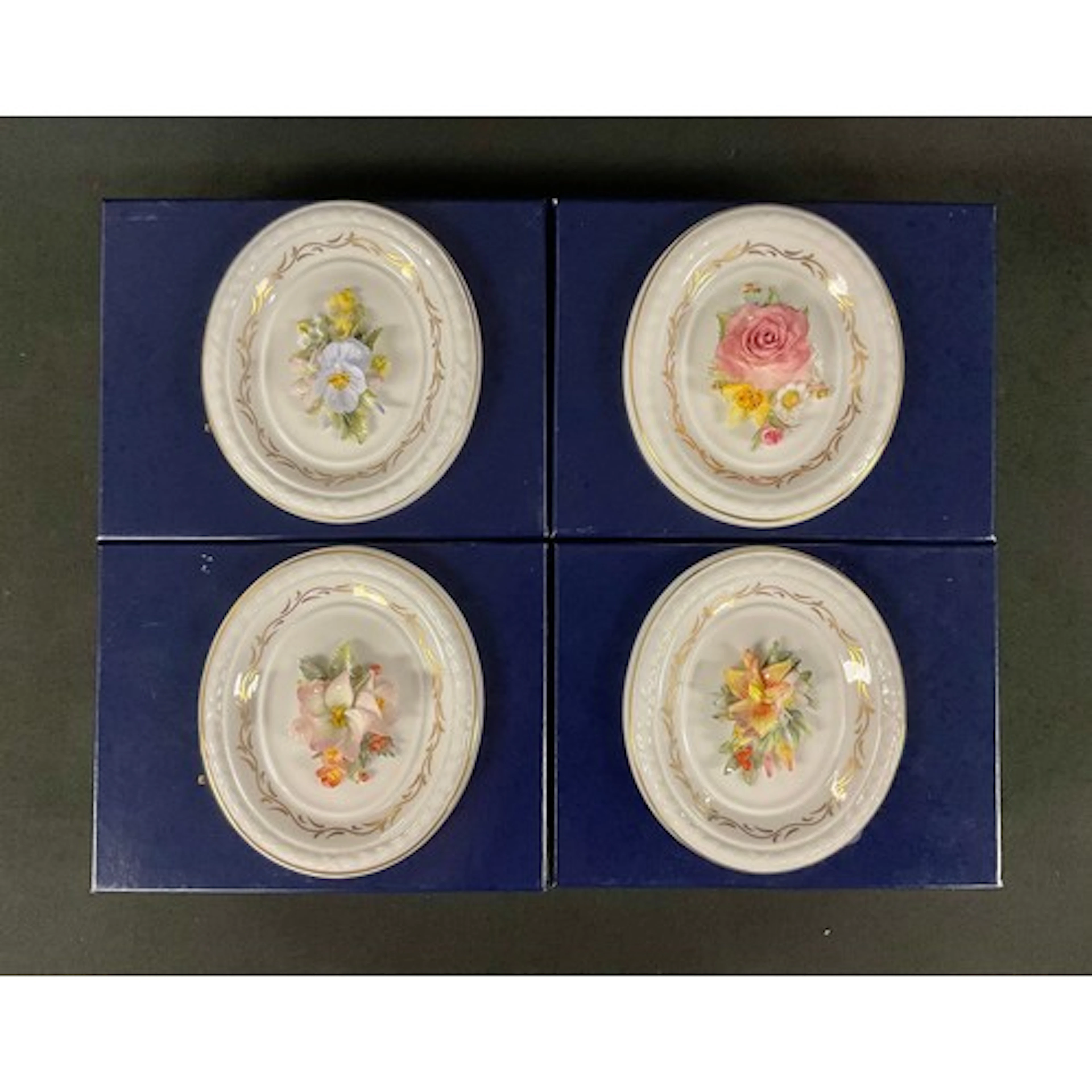 A Royal Crown Derby oval plaque, encrusted with lilies and h...