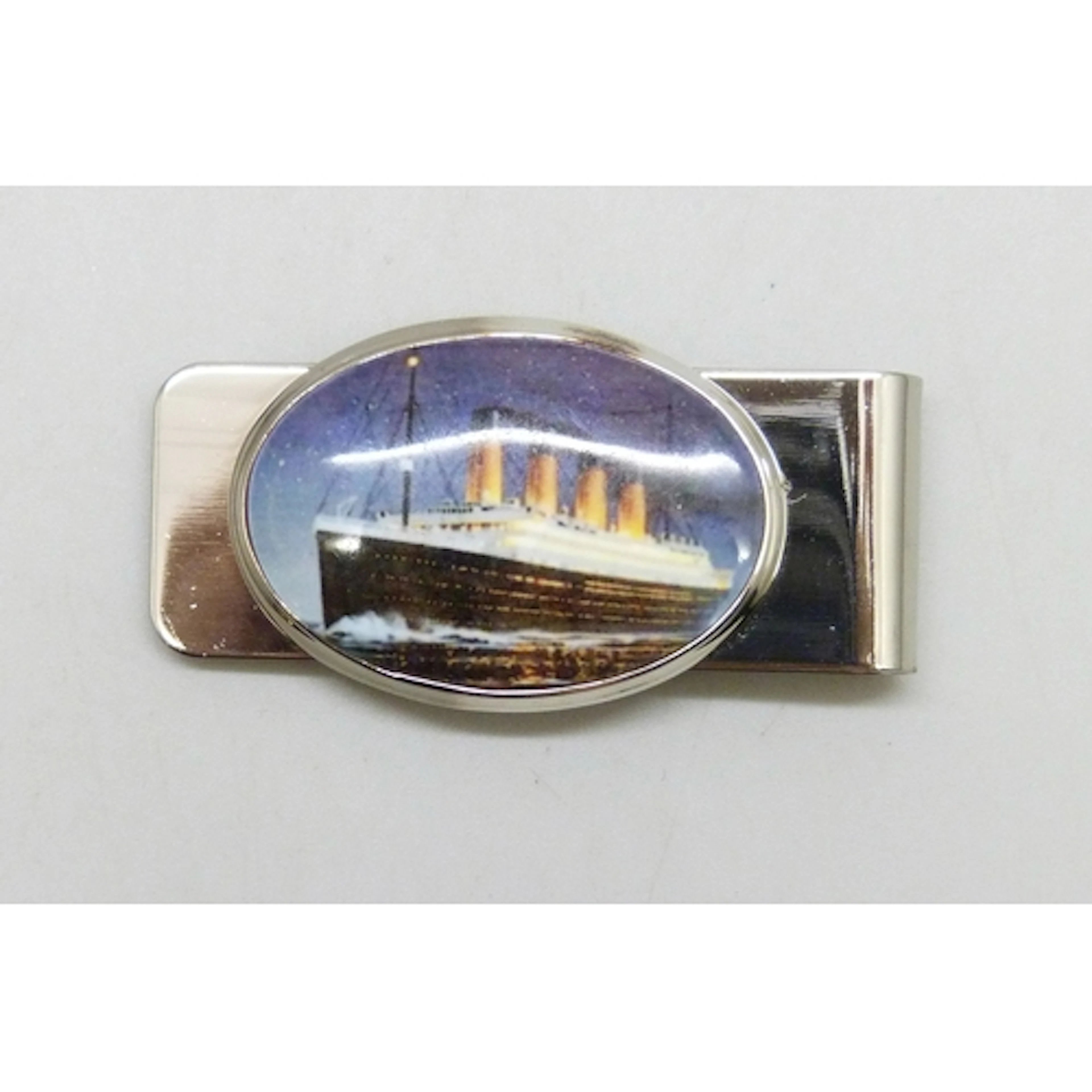A modern silver money clip with printed ceramic plaque depic...