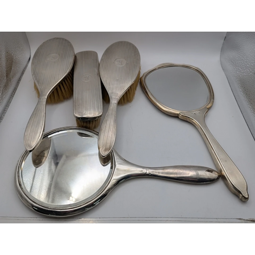 A four-piece silver dressing table set to include two circul...